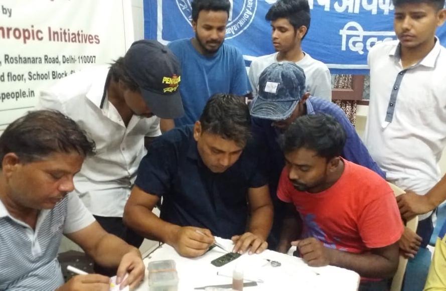 Rough sleepers take part in a mobile-phone repair course run by Delhi's leading homeless charity