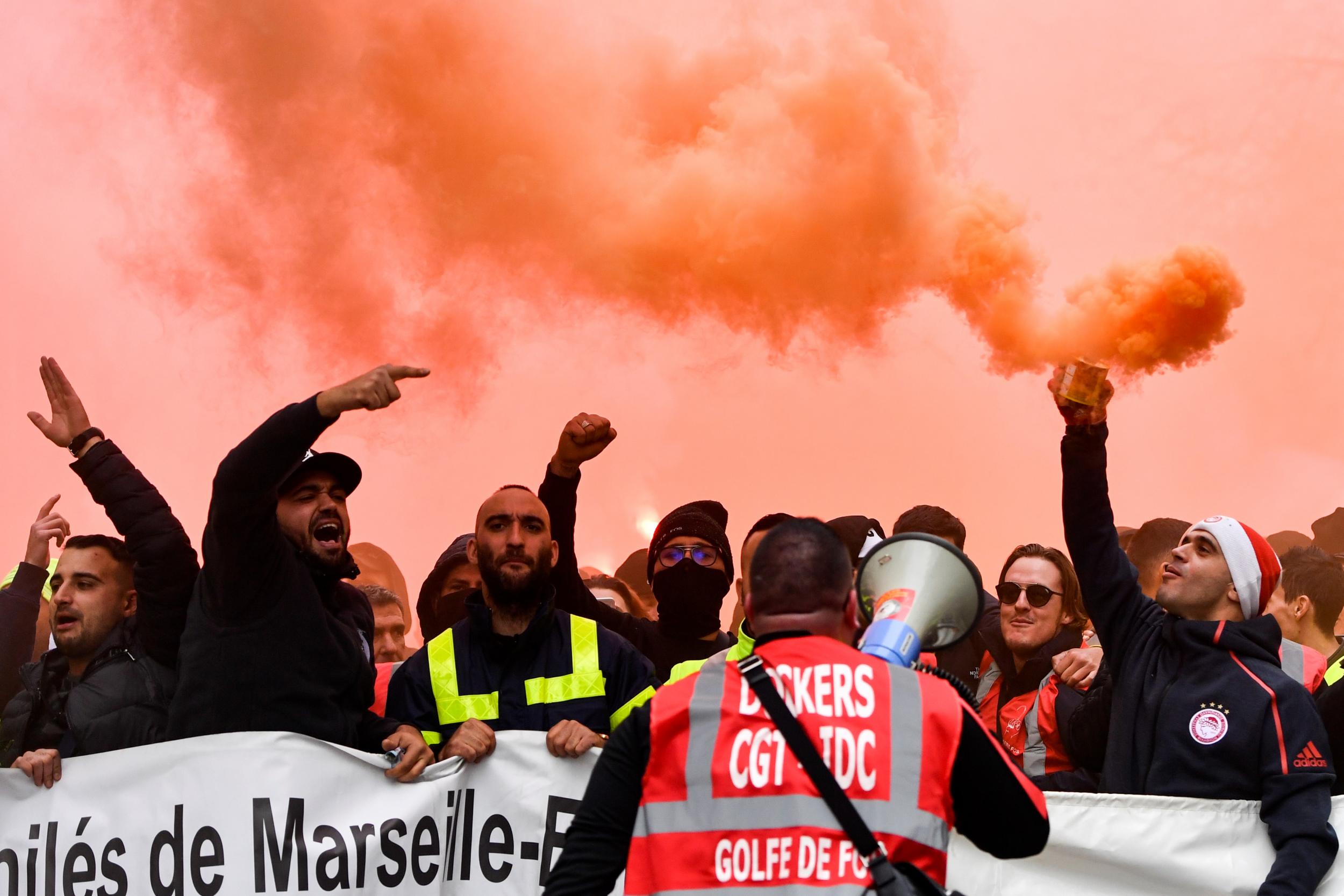 Dockers hold smoke bombs as they take part in protests in Marseilles