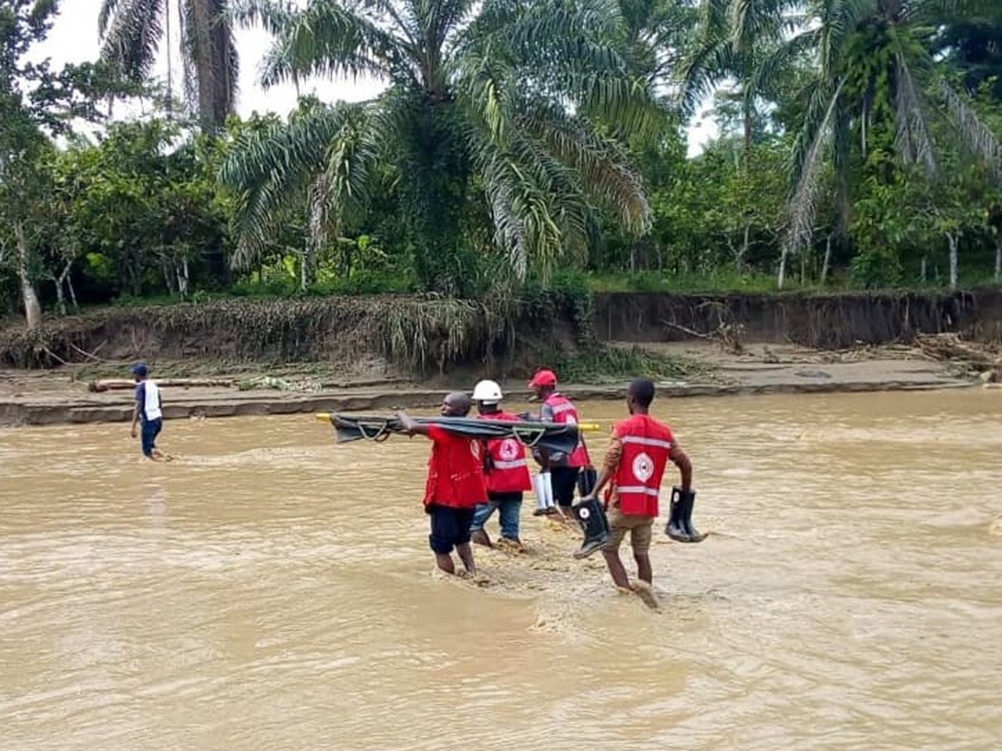 Members of the Ugandan Red Cross carry a dead body after flooding and landslides left 16 dead in western Uganda