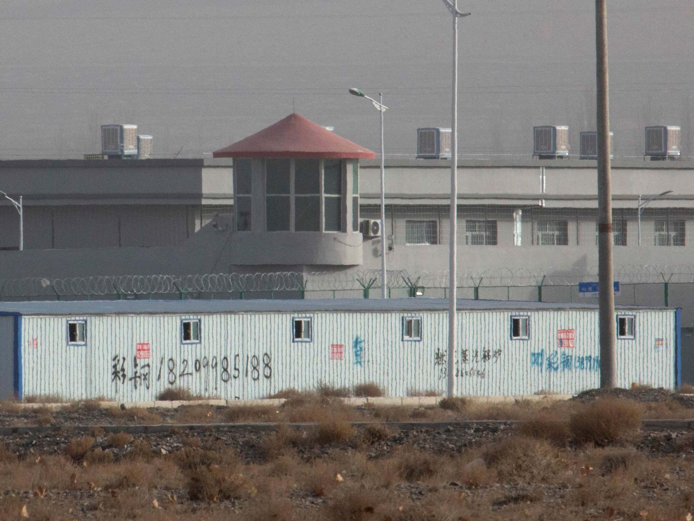 A guard tower and barbed wire fences are seen around a facility in the Kunshan Industrial Park in Artux in western China's Xinjiang region