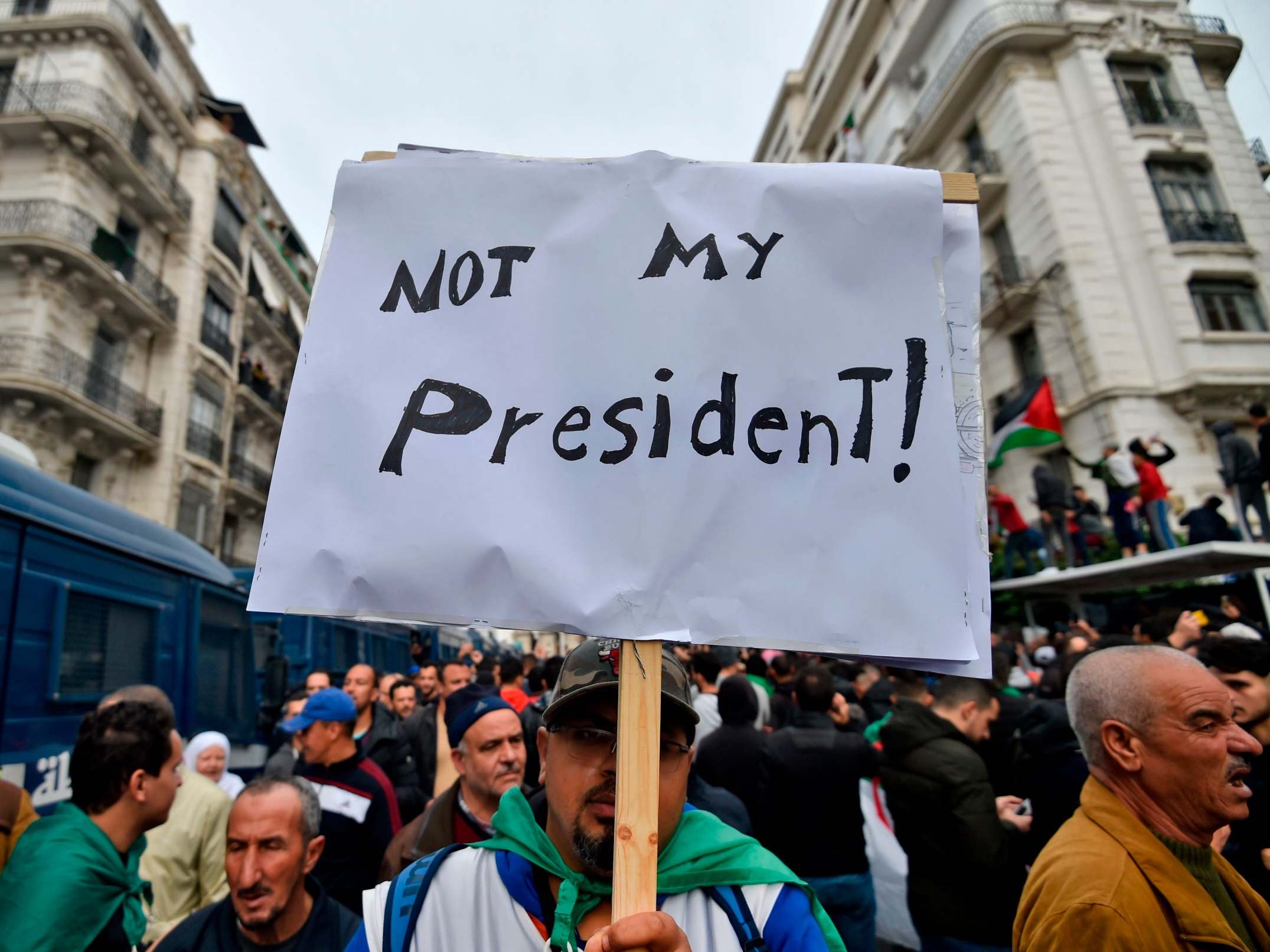 An Algerian protester lifts a placard in the capital Algiers during a demonstration against the election results