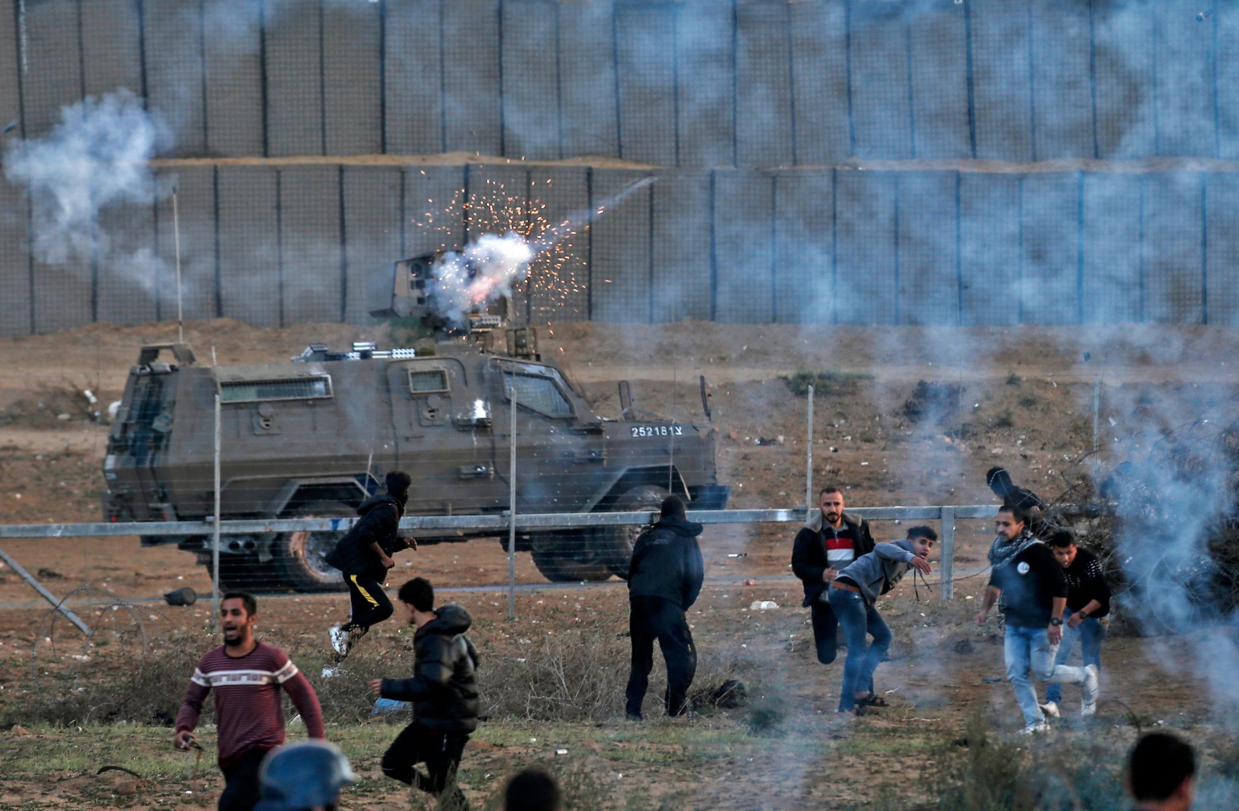 Palestinian protesters run from teargas fired by Israeli forces amid clashes along the border with Israel, east of Bureij in the central Gaza Strip this month (AFP/Getty)