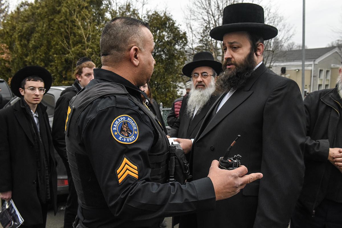 A police officer speaks with the Jewish community in the aftermath of the attack