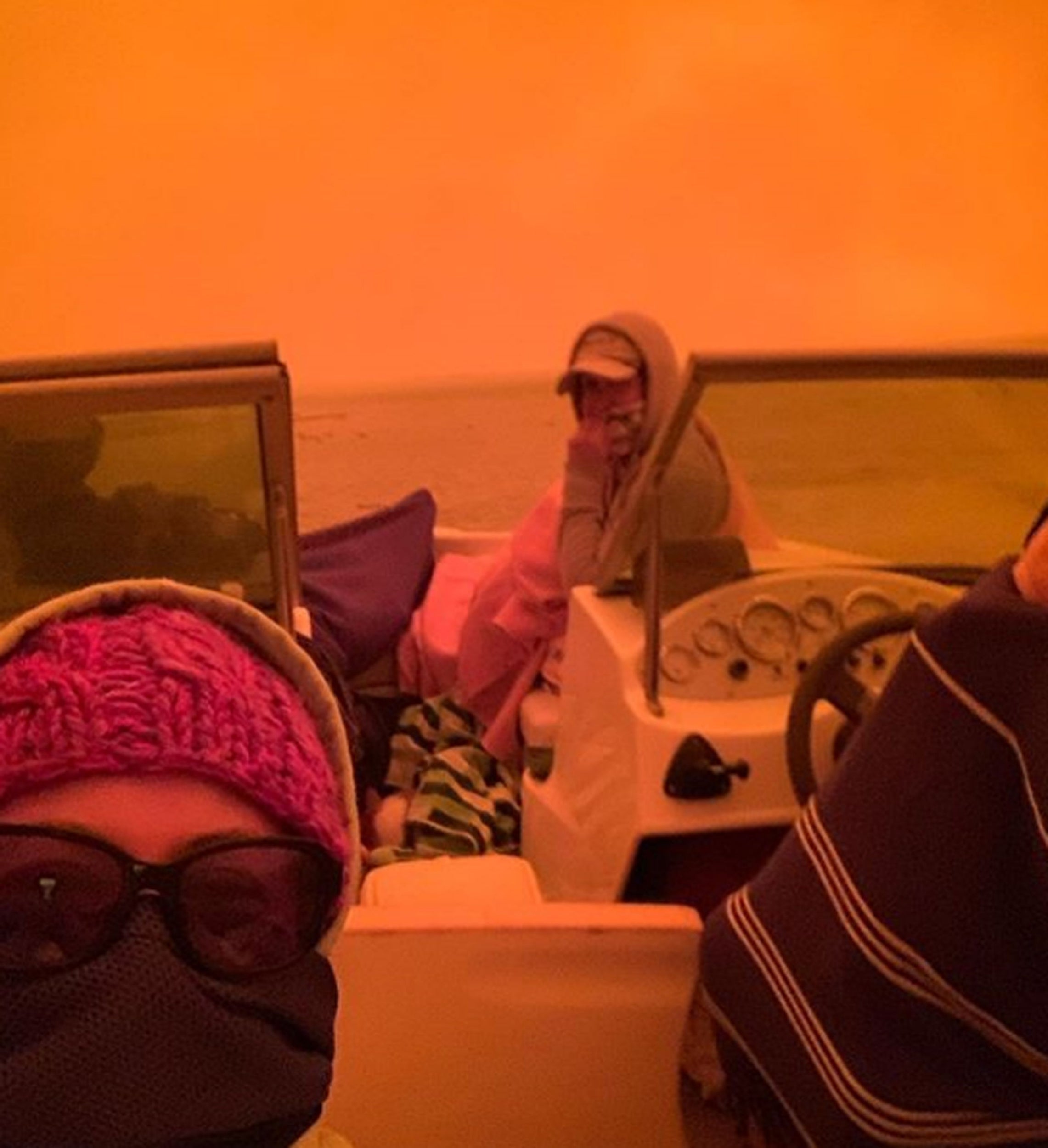 People take shelter on a boat just offshore as bushfires rage in the area around Mallacoota