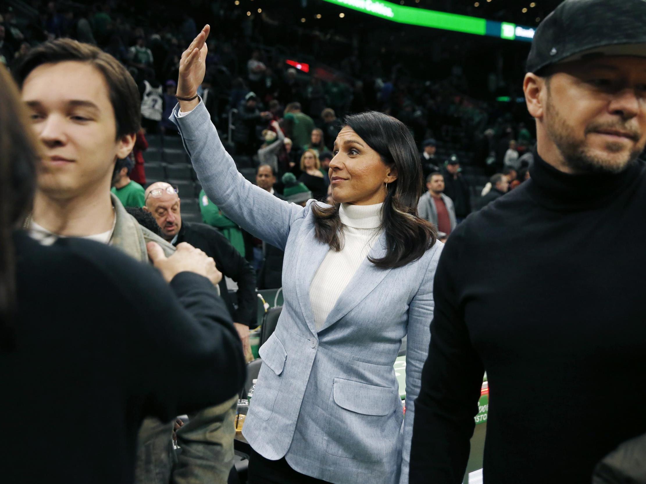 Presidential candidate, U.S. Rep. Tulsi Gabbard, D-Hawaii, center, gestures following an NBA basketball game between the Boston Celtics and the Toronto Raptors