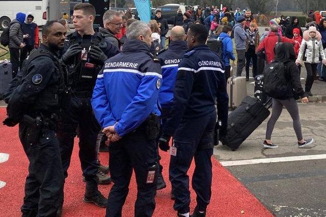 Waiting game: French police watch the crowd of Tui holidaymakers who were told to wait in a car park for five hours