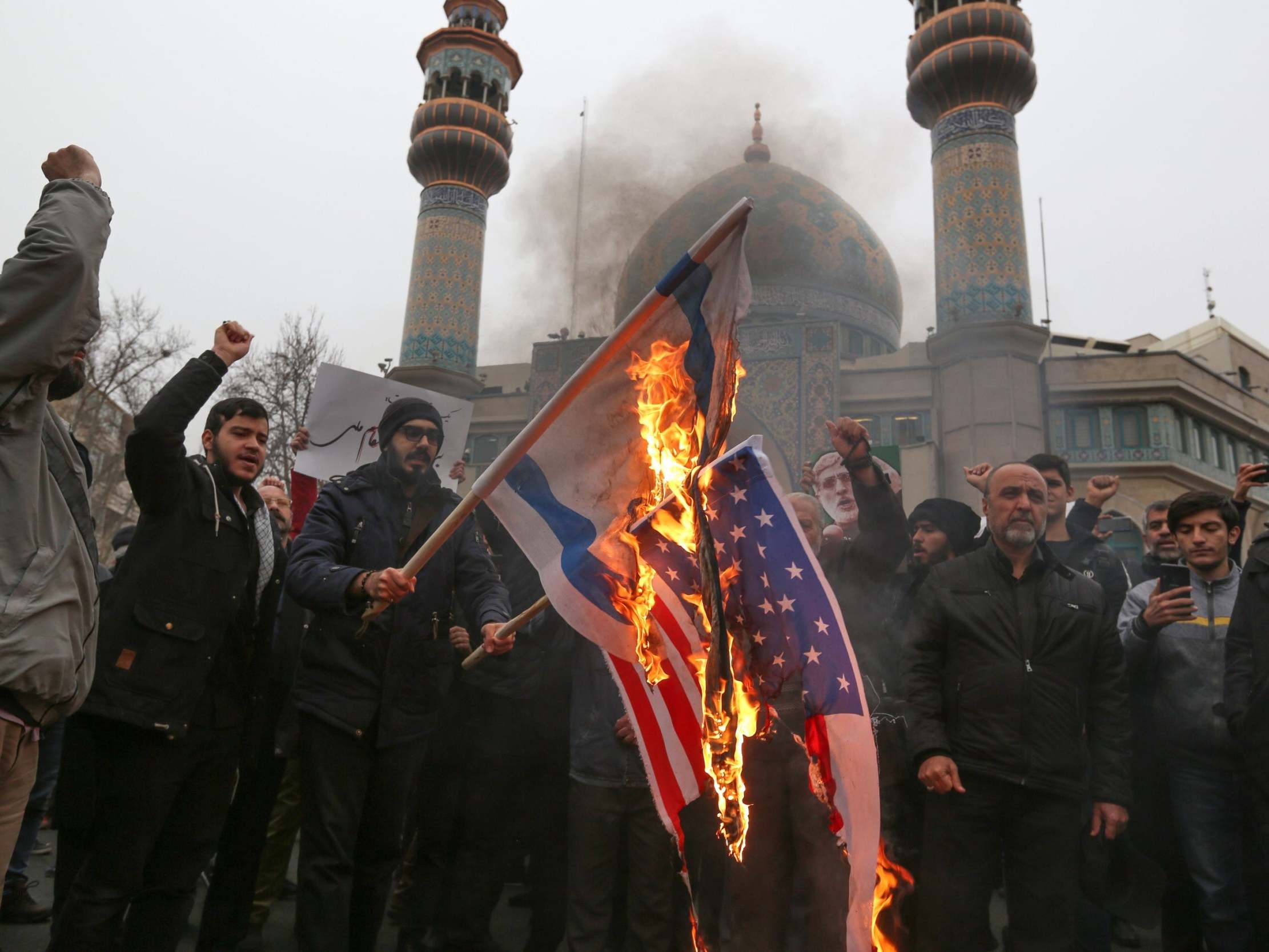 Iranians burn US and Israeli flags during an anti-US protest over the killings during a US air strike of Iranian military commander Qasem Soleimani and Iraqi paramilitary chief Abu Mahdi al-Muhandis, in the capital Tehran on January 4