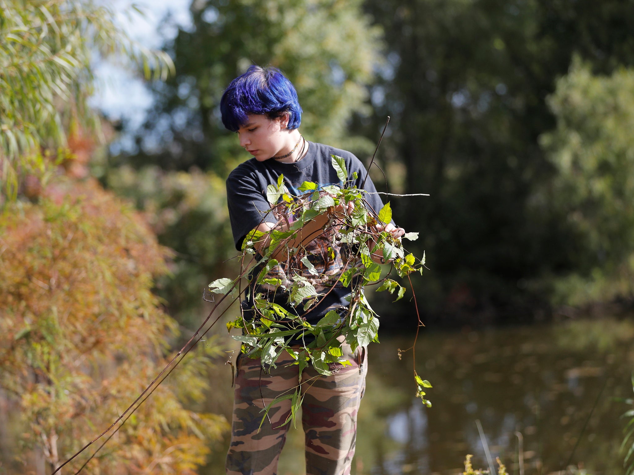 A student works on a restoration project at the Sankofa Wetland Park and Nature Trail in New Orleans