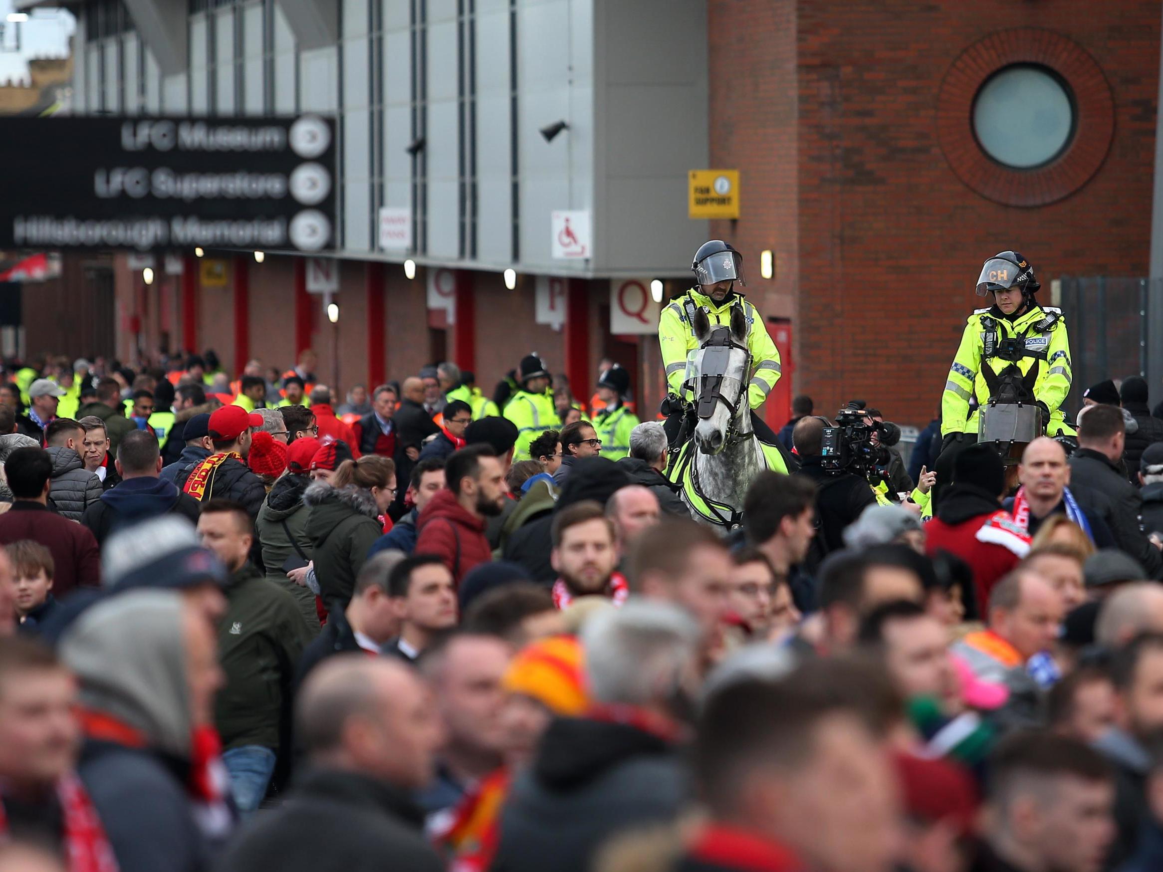 Police officers watch over the fans ahead of Liverpool vs Everton