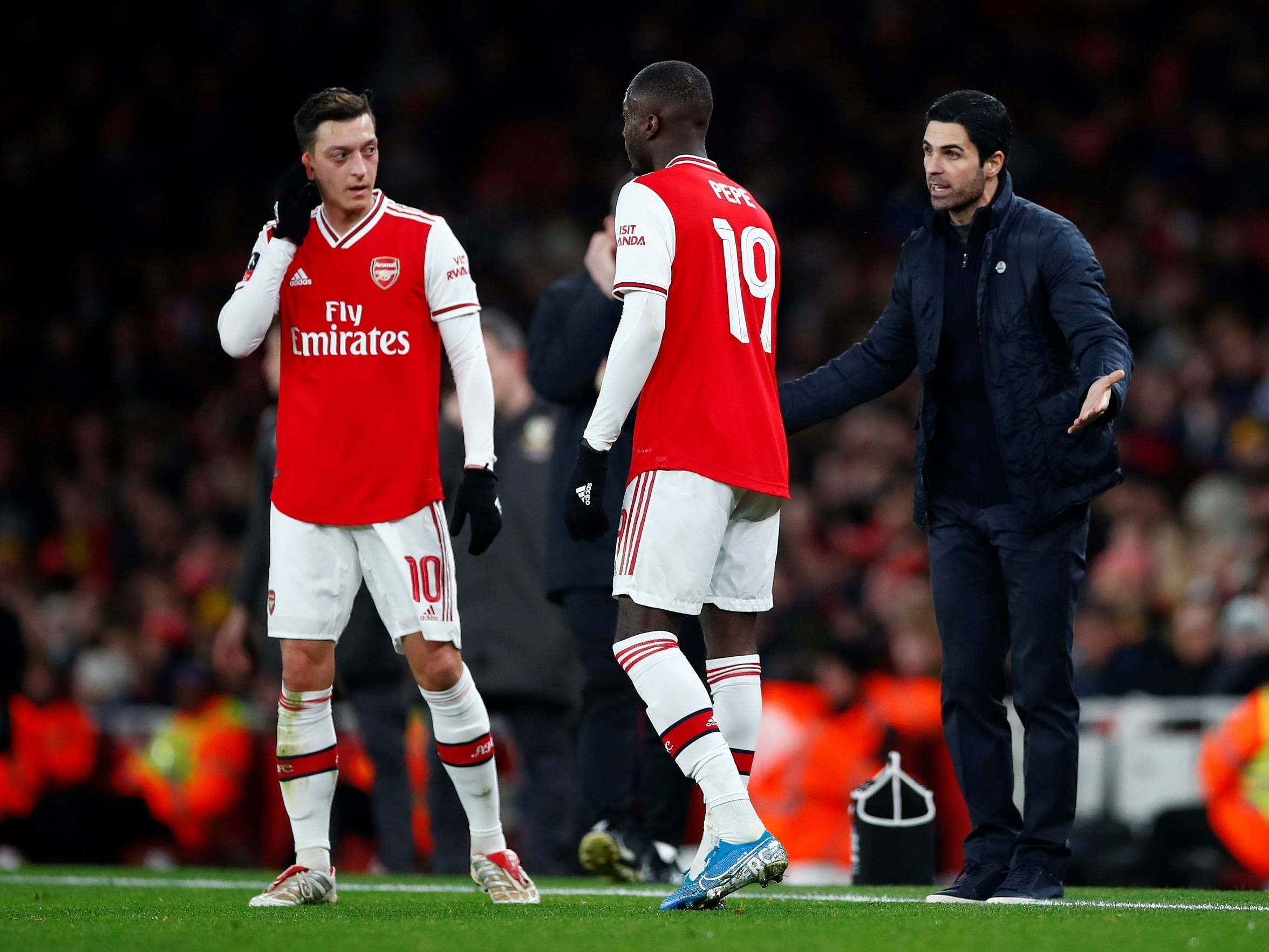 Arsenal manager Mikel Arteta reacts with Nicolas Pepe and Mesut Ozil