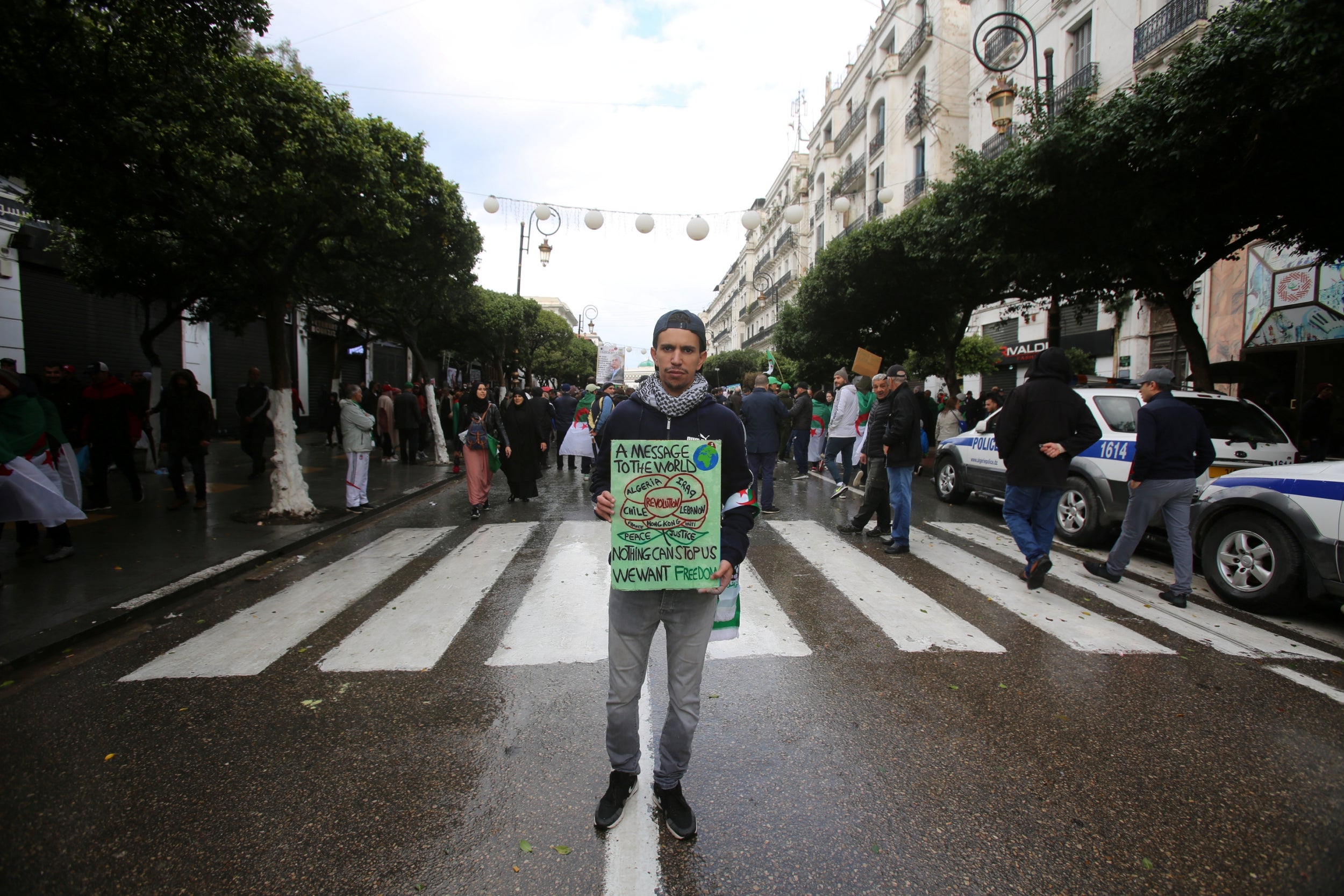 Amiri Yacine, 26, a student, poses in Algiers for a photograph during a protest rejecting Algeria's ruling elite and its December presidential election