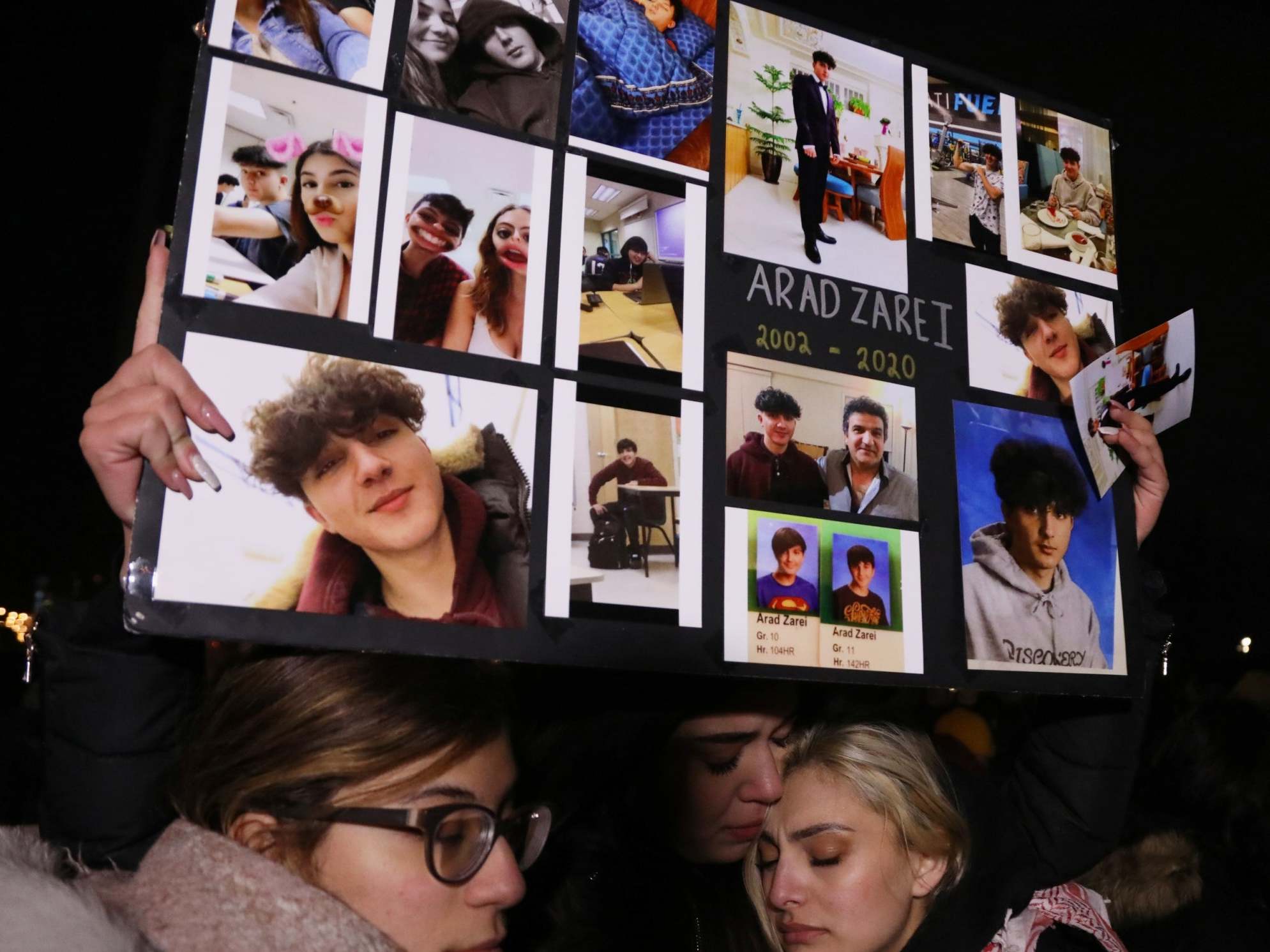 Friends of high school student Arad Zarei hold his pictures as mourners attend an outdoor vigil for the victims of a Ukrainian passenger jet which crashed in Iran (Reuters/Chris Helgren)