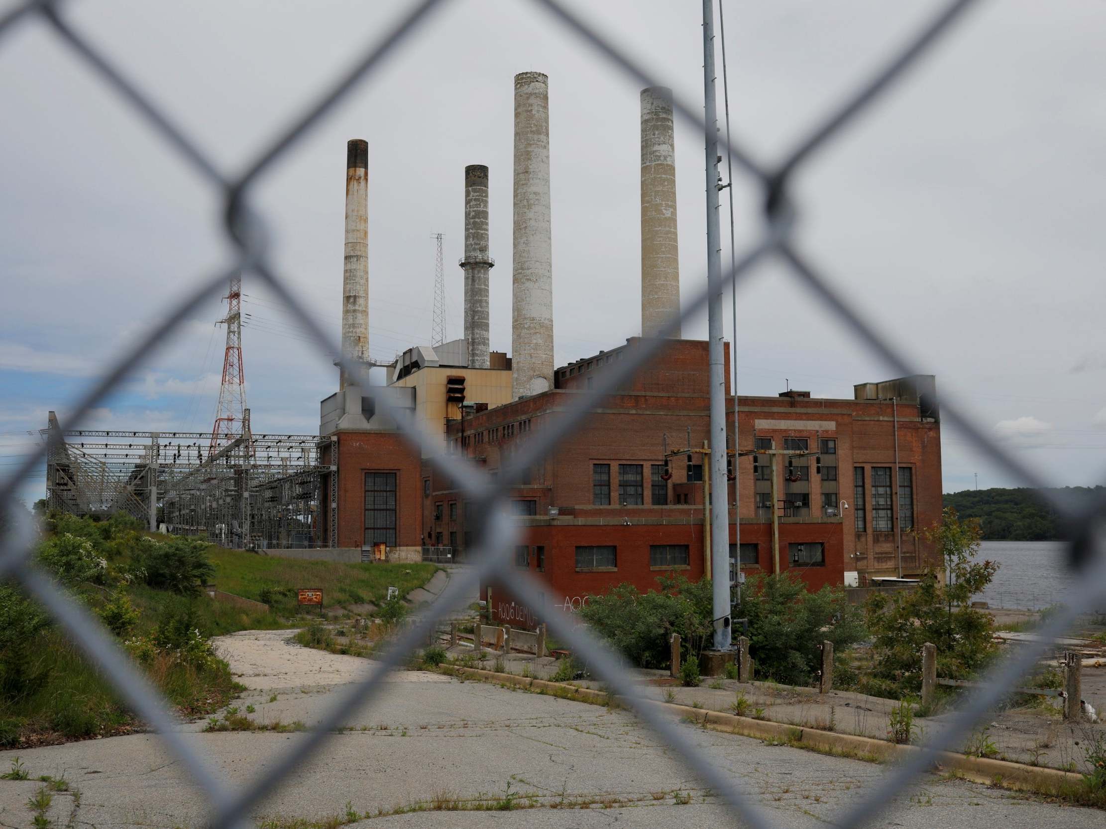 A fence closes off the closed coal-fired Somerset power plant in Somerset, Massachusetts, in 2017