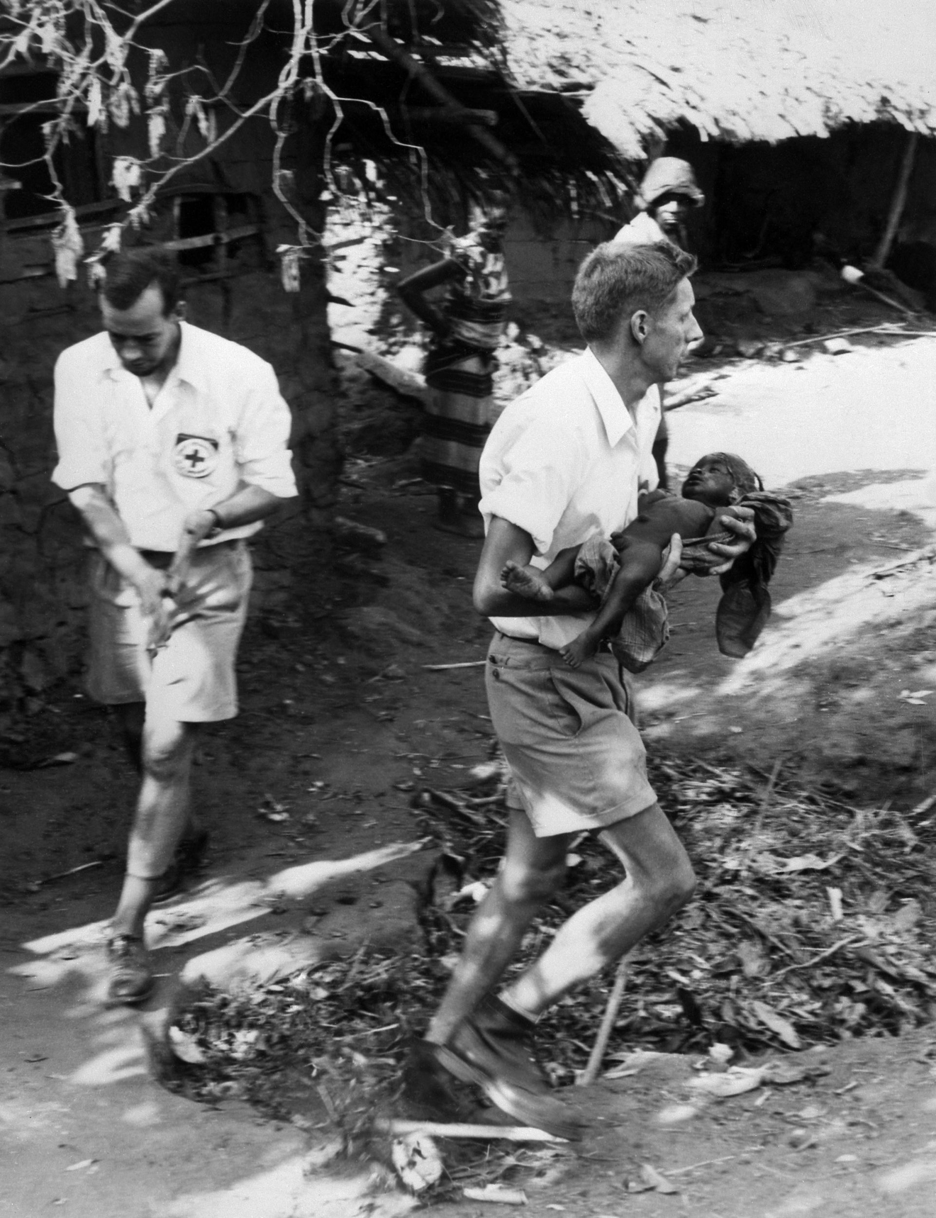 A Red Cross volunteer carries a baby in a Biafran village at the end of the war (AFP/Getty)