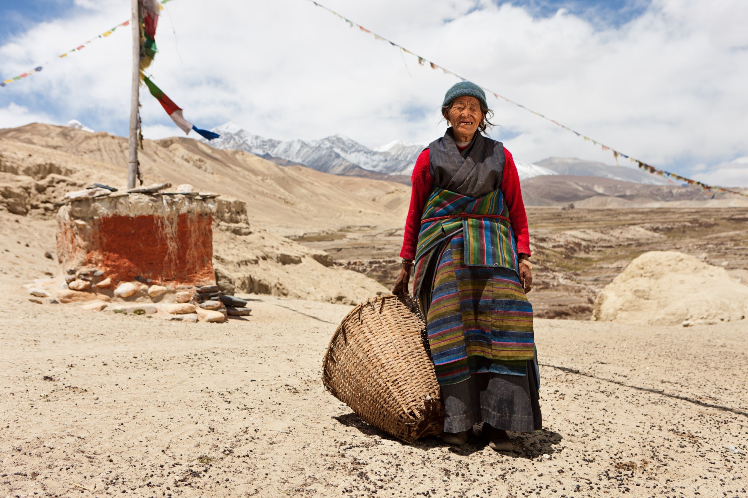 A Nepali woman carries a basket in Lo Manthang​