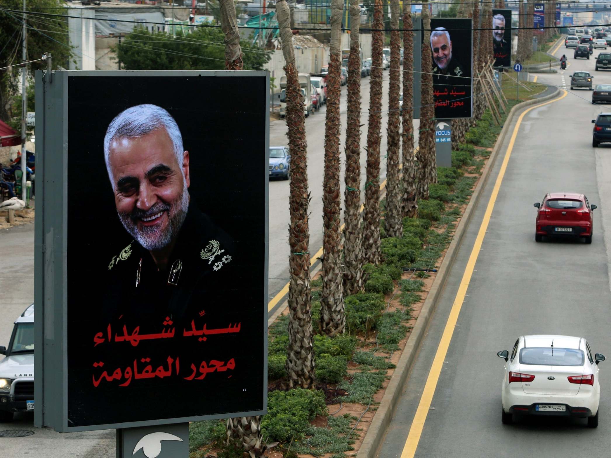 Cars pass a picture of the late Iranian general Qassem Soleimani in the suburbs of Beirut after his killing by a US drone strike