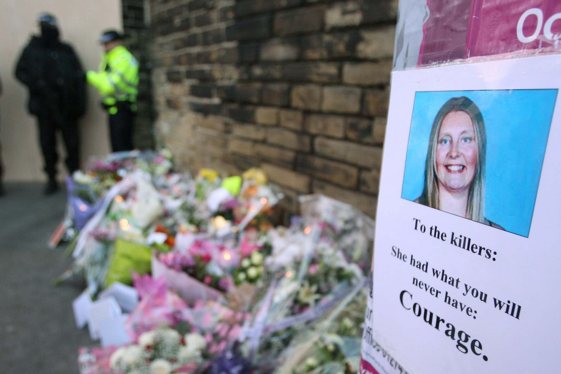 A photograph of the PC beside floral tributes at the scene of the crime