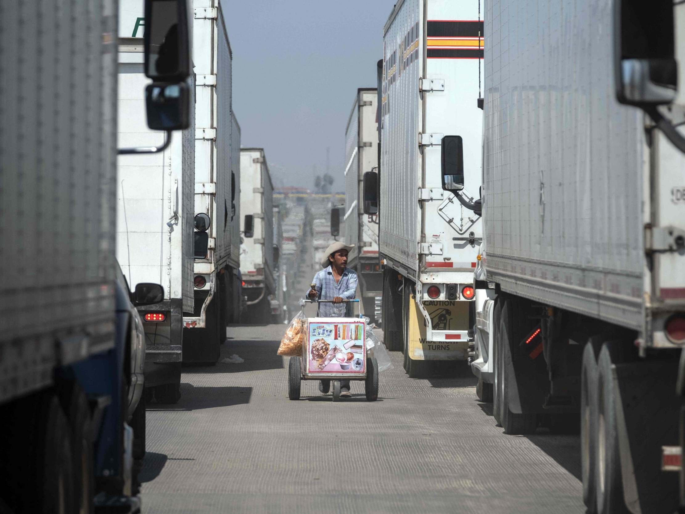 A street vendor sells ice cream to cargo trucks drivers lining up to cross to the United States at Otay commercial crossing port in Tijuana, Baja California state, on June 6, 2019