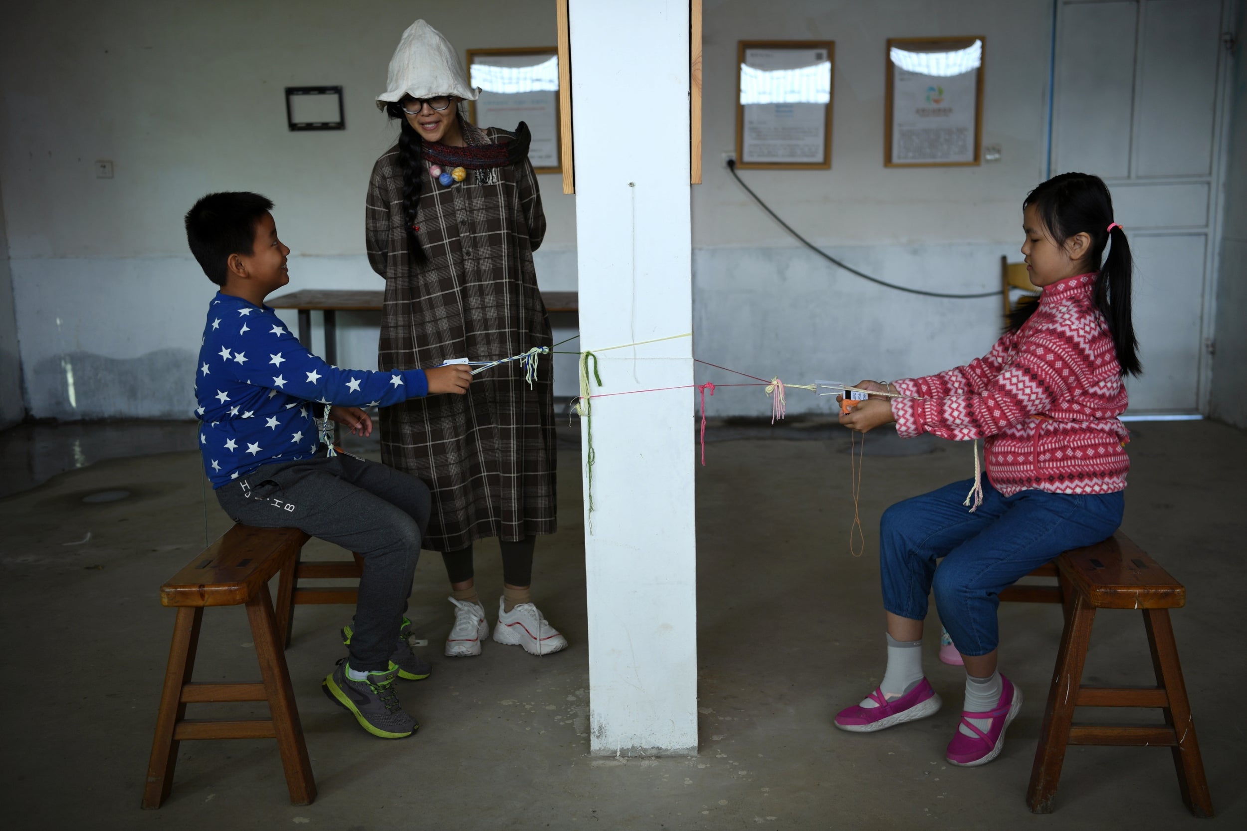 Xing Zhen teaches her students how to weave