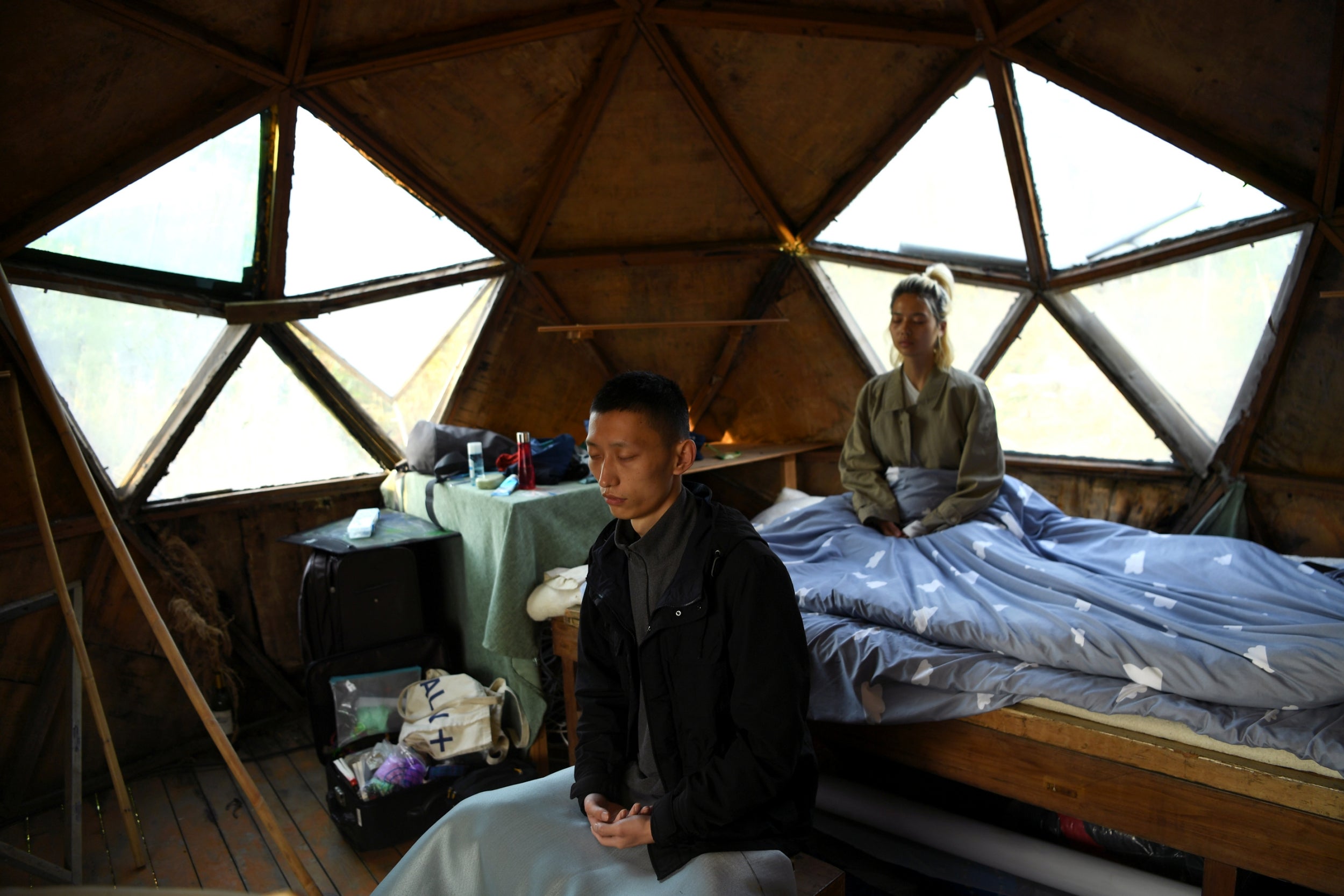 Yang Zhaoyu and Chen Yan meditate in the early morning inside a dome-shaped house on a hill at AnotherCommunity