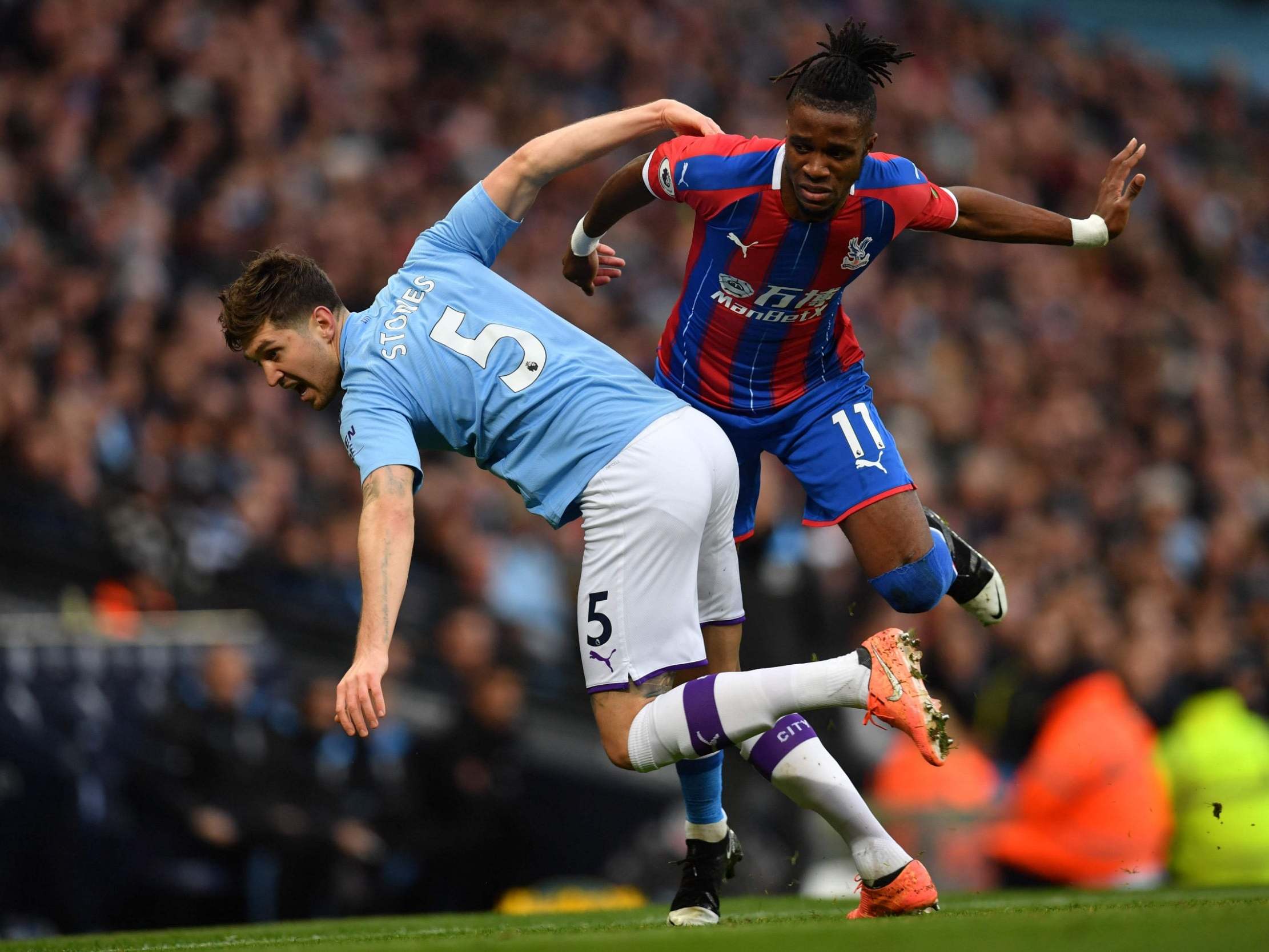 Manchester City's John Stones and Crystal Palace's Wilfried Zaha