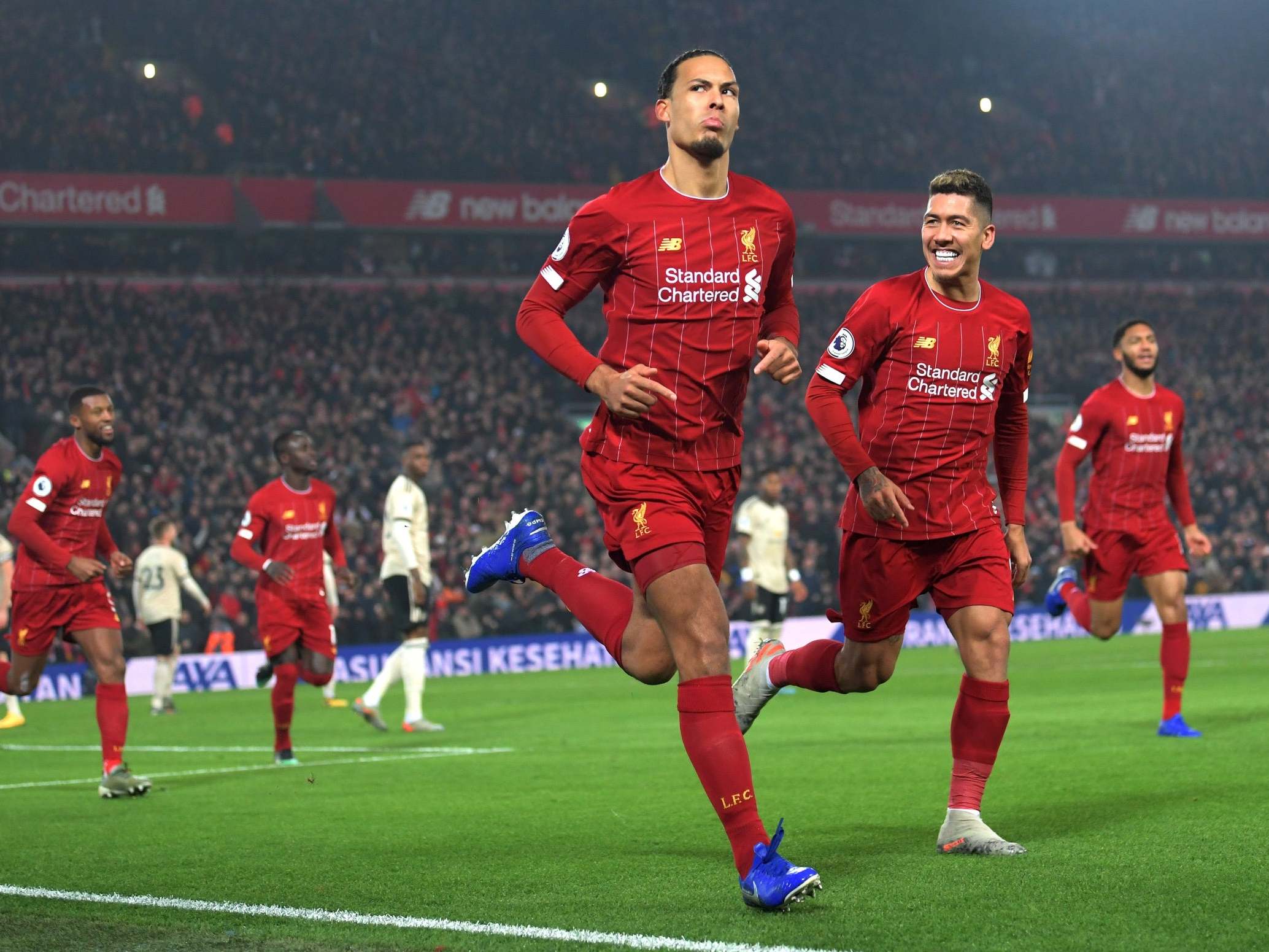 Virgil van Dijk of Liverpool celebrates with Roberto Firmino