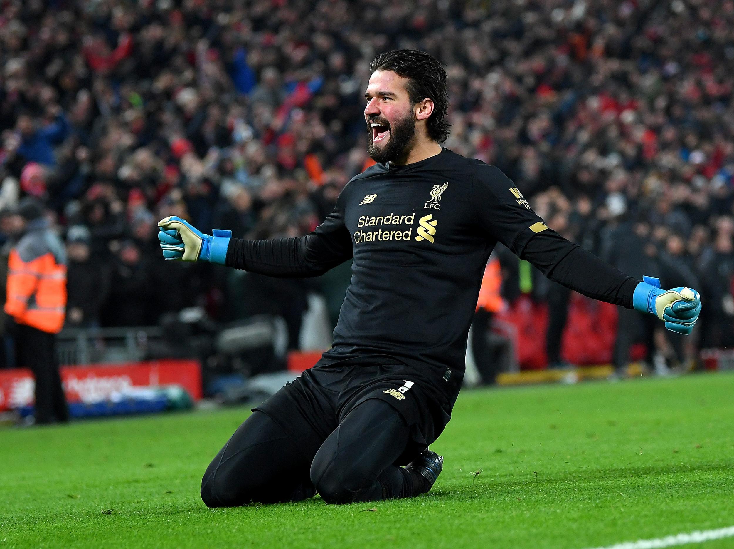 Alisson celebrates his assist against Manchester United