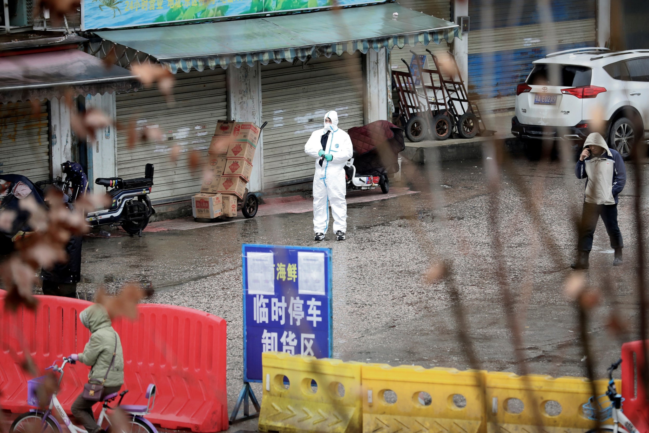 A health worker in a protective suit is seen at the closed seafood market in Wuhan