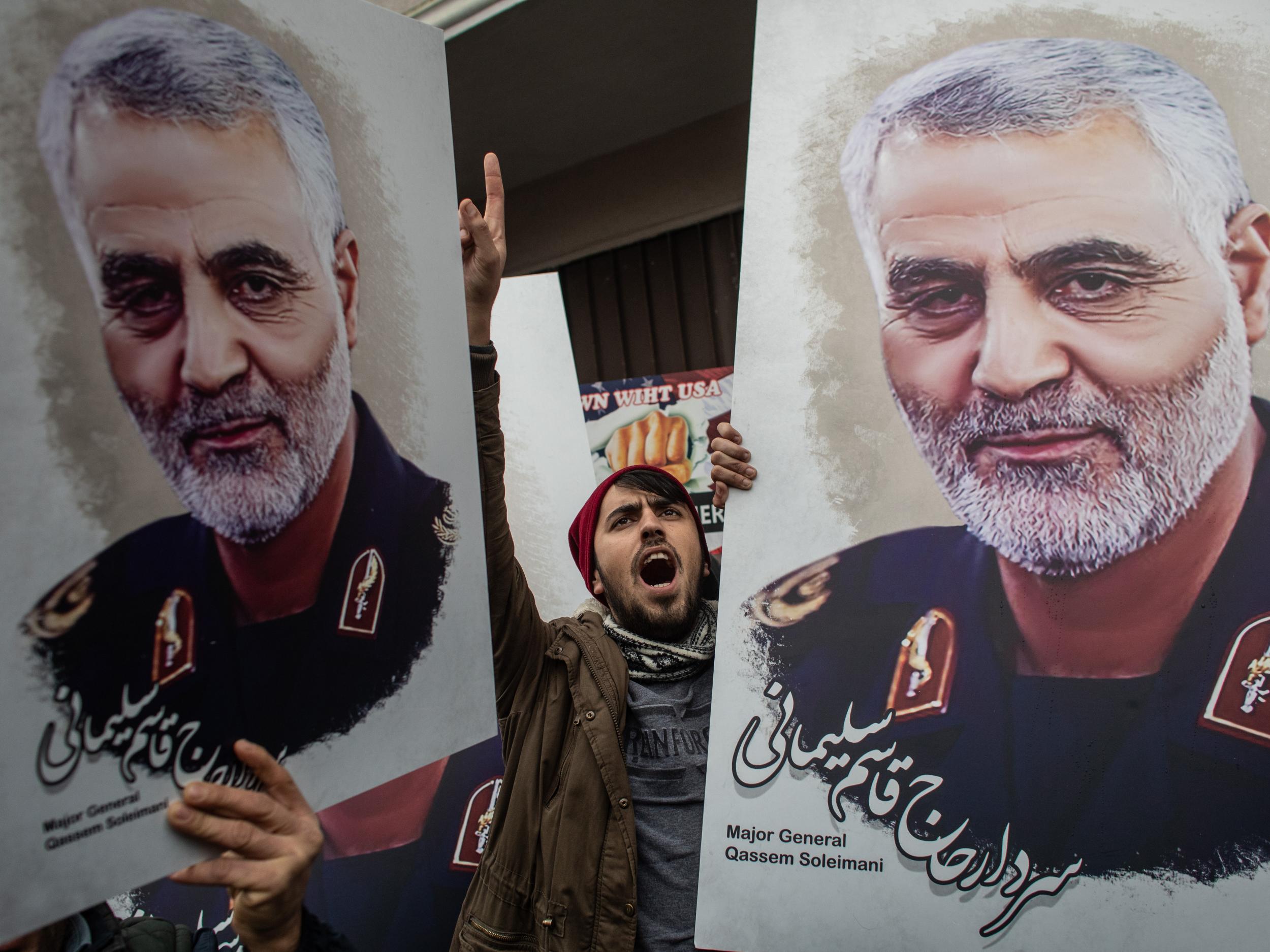 Mourners in Iran hold pictures of Maj. Gen. Qasem Soleimani, who was killed by US military forces in Iraq. Getty