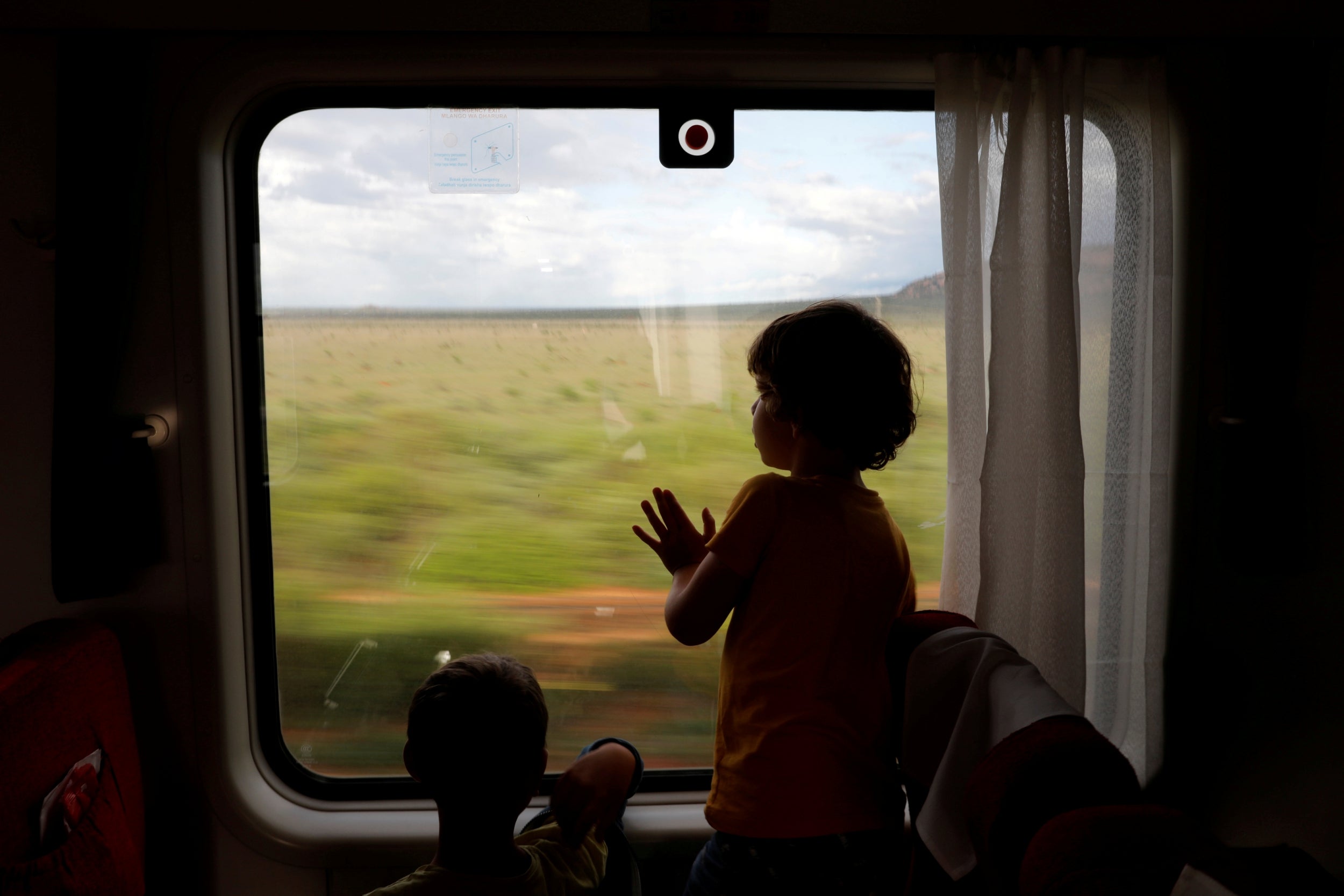 Children look out of the window of a train from Mombasa to Nairobi