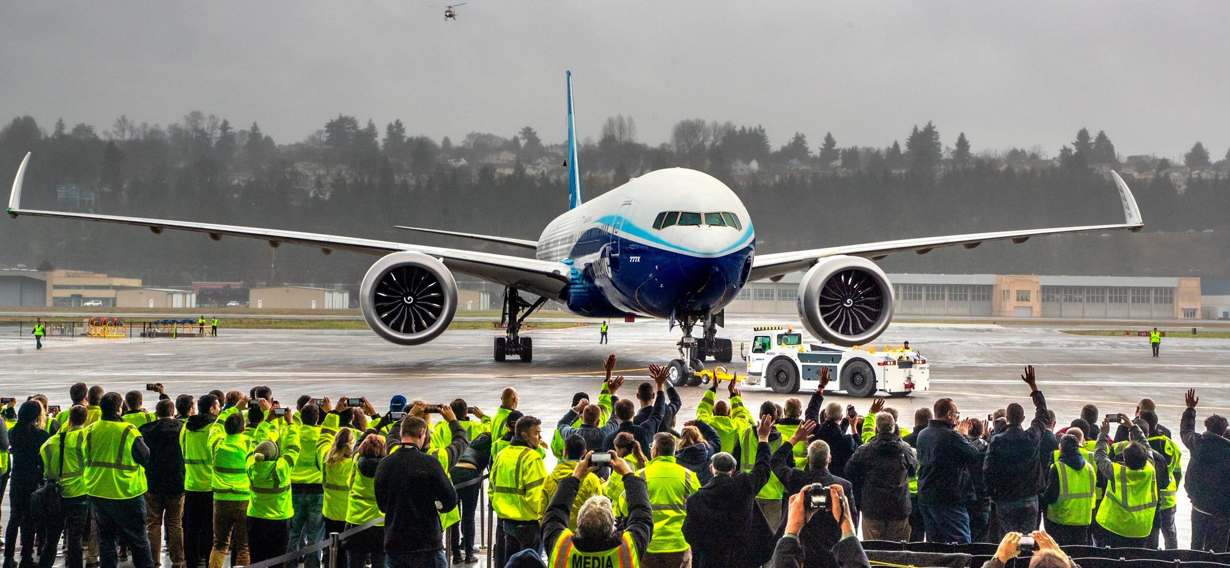 Boeing employees and family members cheer the 777X after it landed at Boeing Field in Seattle