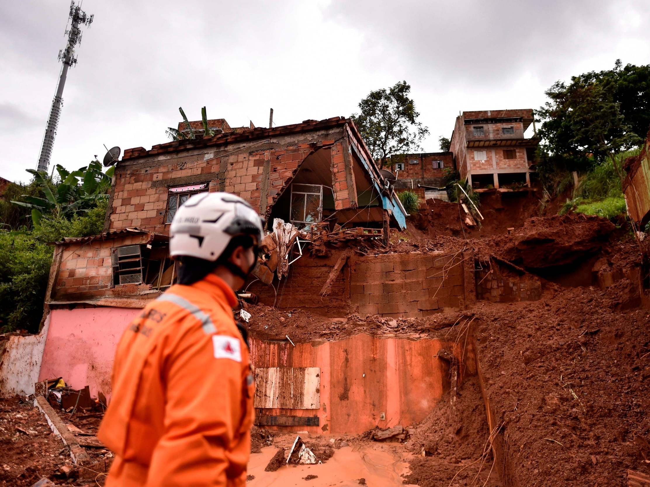 A firefighter looks at the site of a landslide in Belo Horizonte