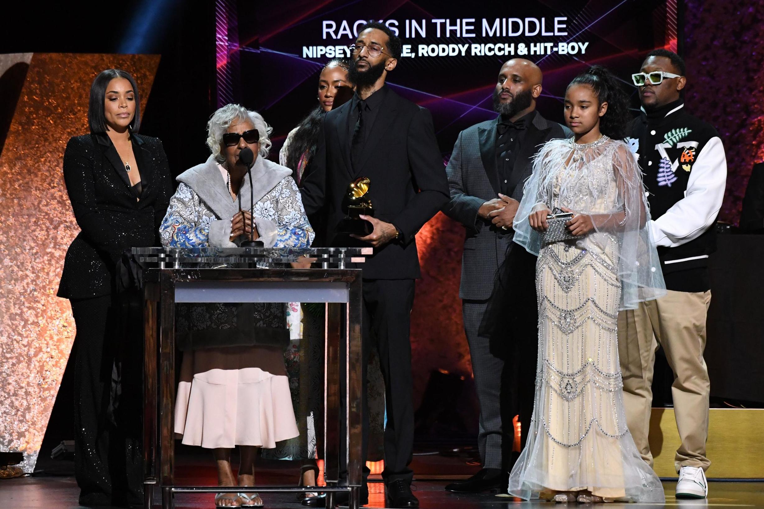 Samiel Asghedom (center), brother of late rapper Nipsey Hussle, his partner Lauren London (left), his grandmother (second left), and other relatives accept the award for Best Rap Performance for “Racks in the Middle” during the 62nd Annual Grammy Awards pre-telecast show on January 26, 2020, in Los Angeles.