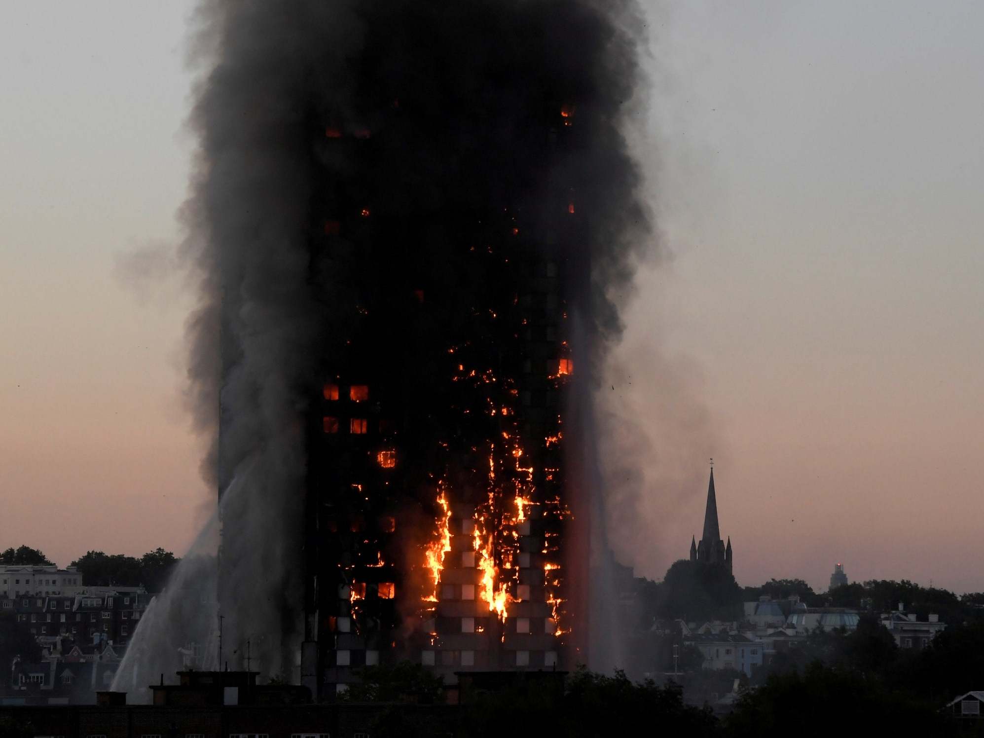 Flames and smoke billow as firefighters deal with a serious fire in the Grenfell Tower apartment block