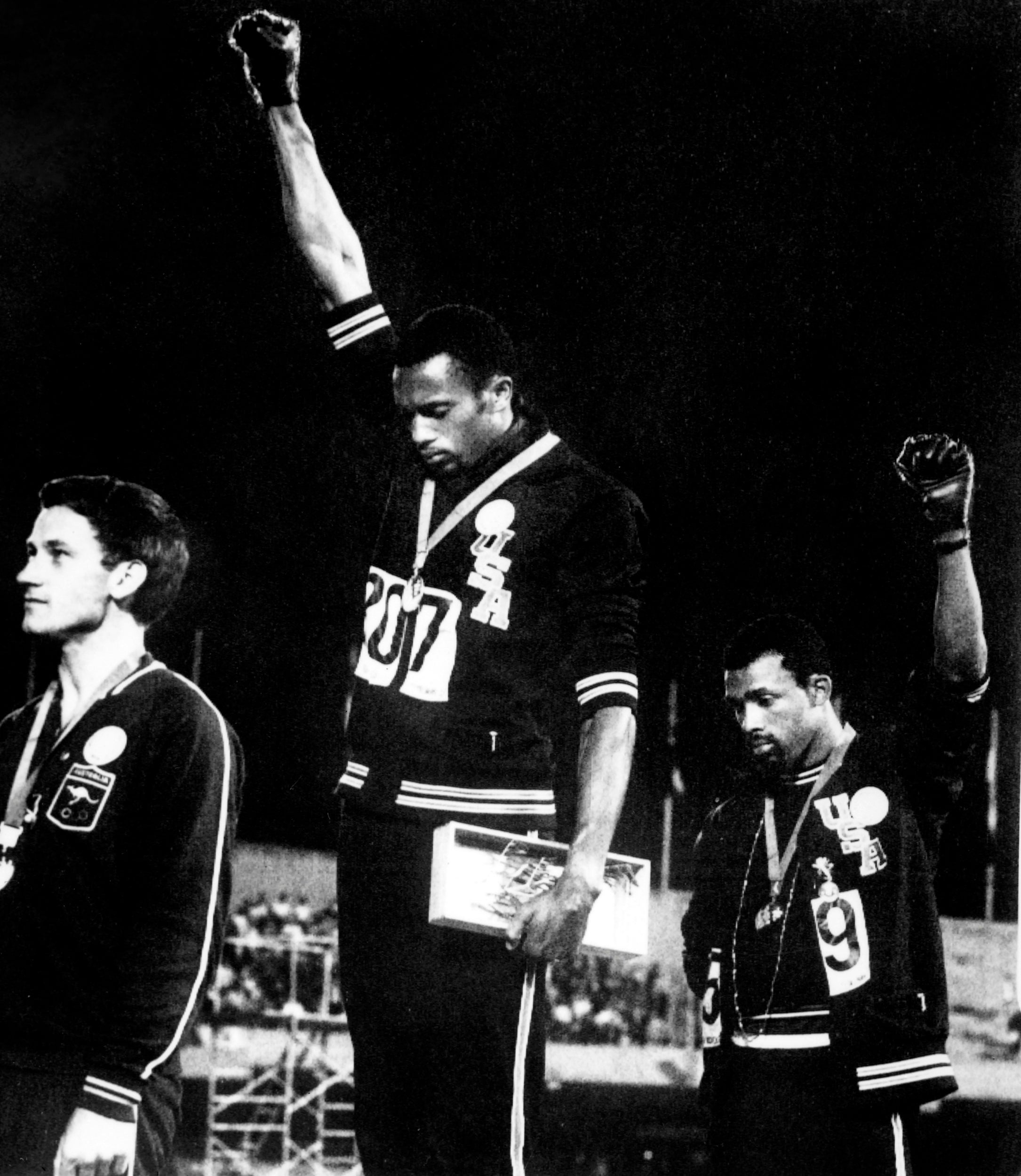 Tommie Smith (centre) and John Carlos give the Black Power salute during the US national anthem in the 1968 Mexico Olympics (AFP via Getty)