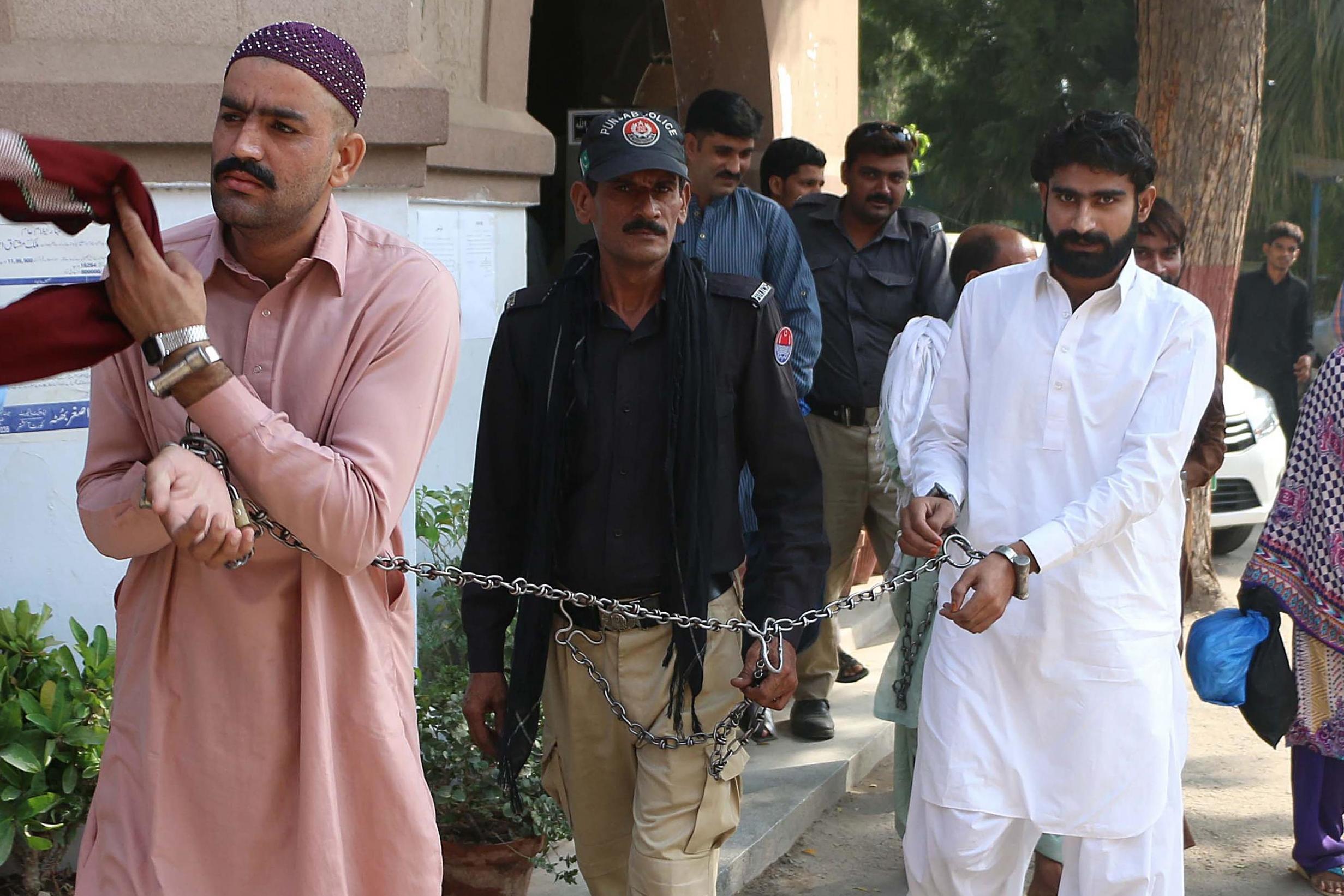 Waseem Azeem (right) and his cousin are escorted by police as they arrive at a local court in Multan (AFP/Getty)