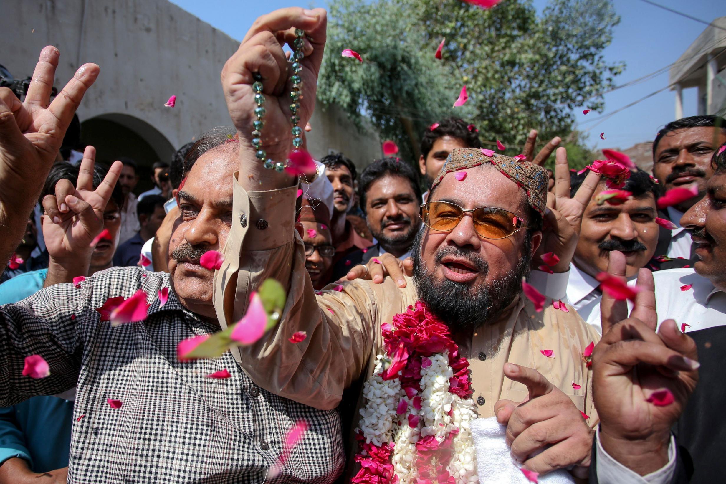 Supporters shower rose petals on Islamic cleric mufti Abdul Qavi (right) after he is acquitted by the court of involvement in Baloch’s murder (AFP/Getty)