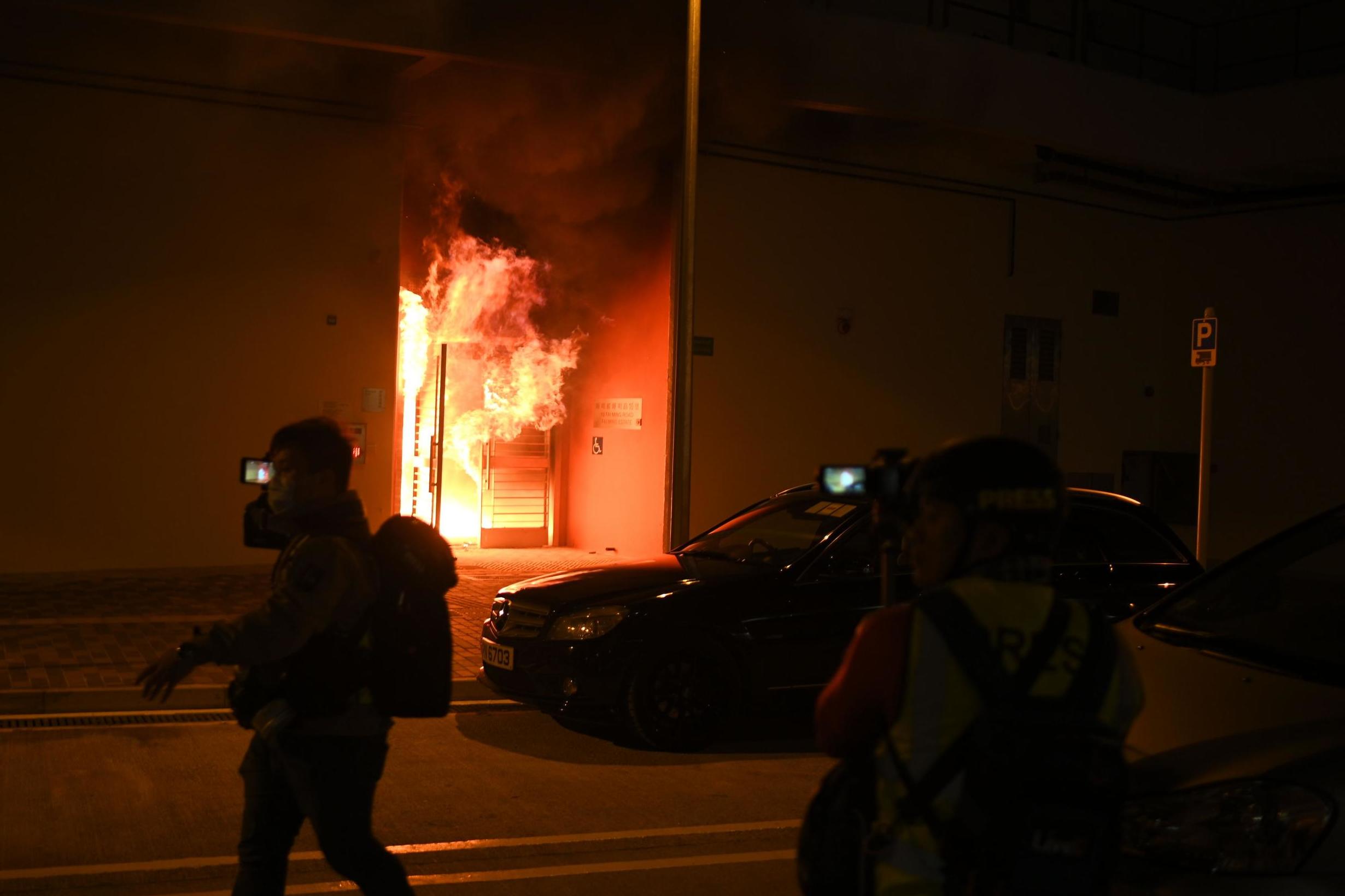 An apartment block earmarked as a quarantine zone burns after protestors threw Molotov cocktails into the lobby