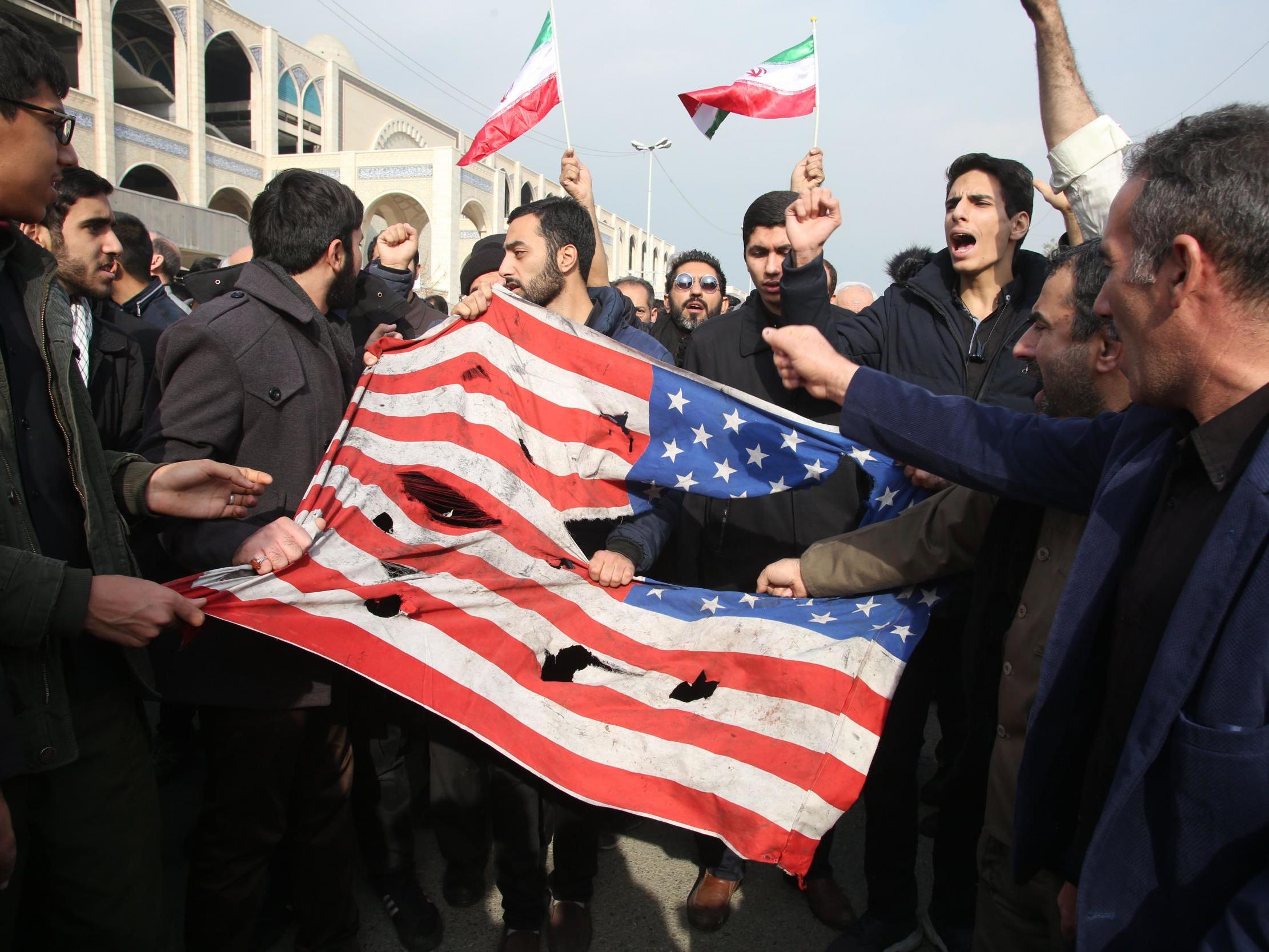 Iranians tear up a US flag during a demonstration in Tehran