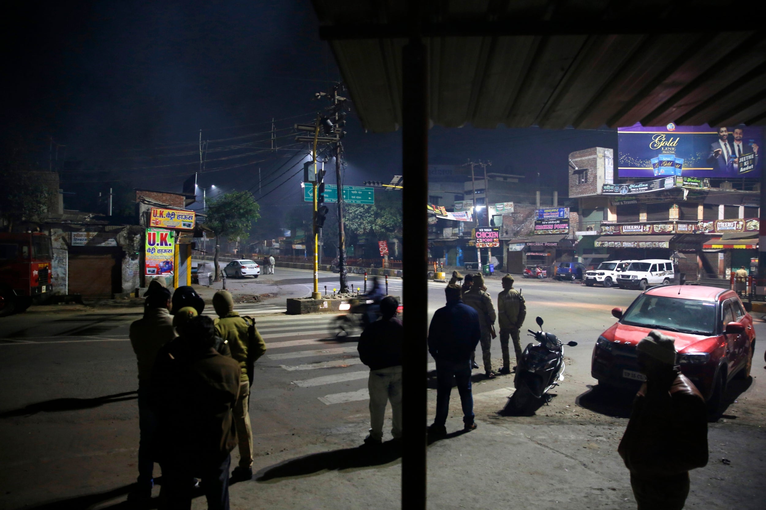 Police guard an area where authorities have sealed shops belonging to those who took part in protests against CAA in Muzaffarnagar