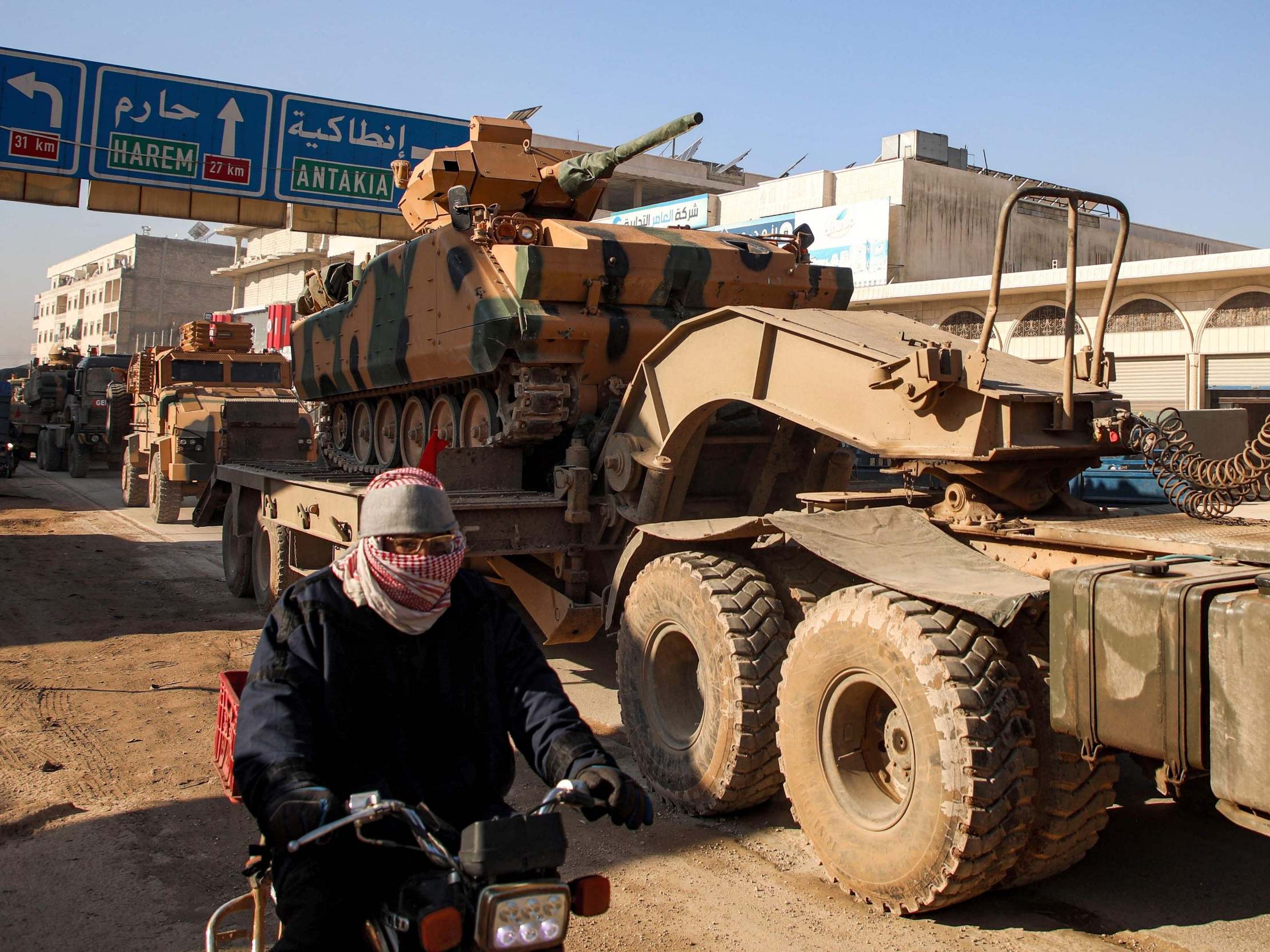 A Turkish convoy of tanks passes through the Syrian town of Dana