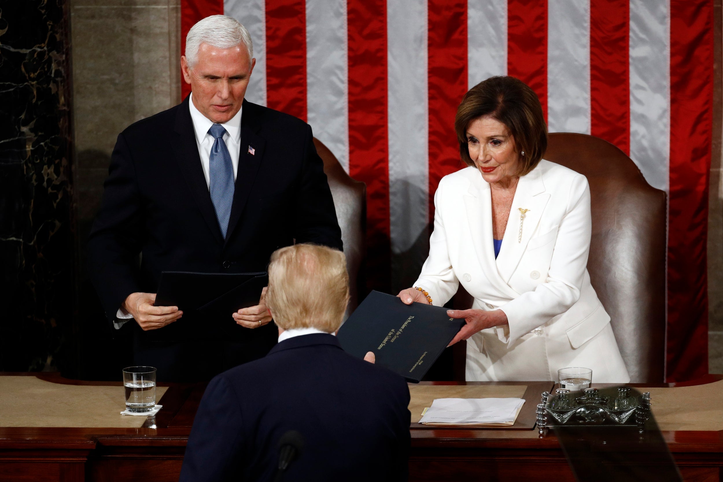 Donald Trump hands a copy of his speech to Nancy Pelosi ahead of his State of the Union address – but he turned away as she reached out to shake his hand