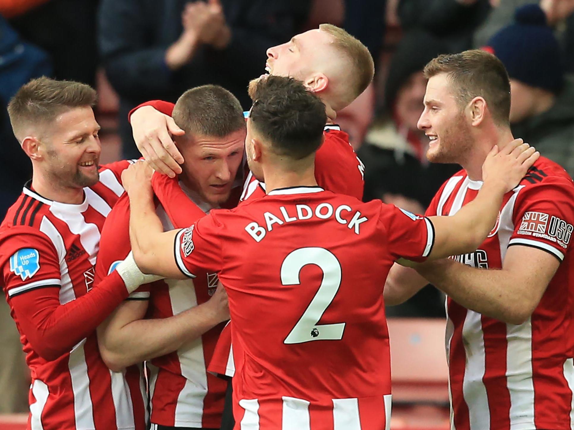 Lundstram is mobbed by his teammates after putting Blades ahead