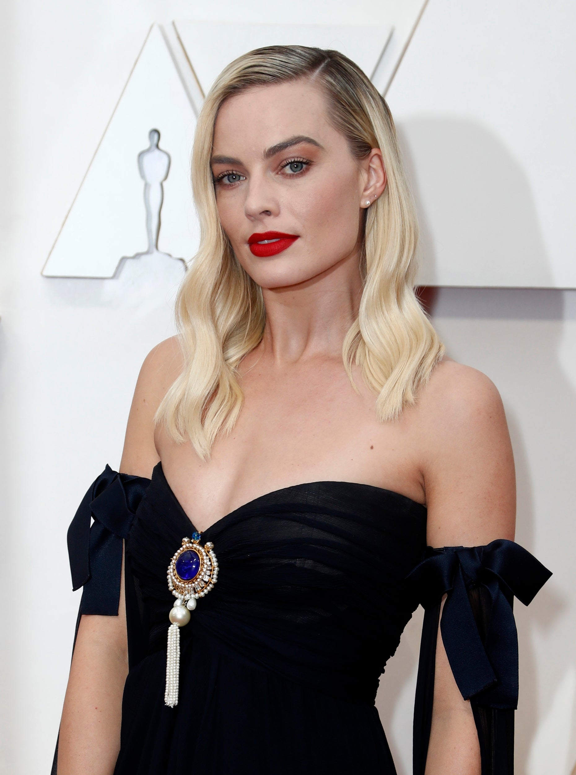 The <i>Bombshell</i> actor added a burst of colour to her look with a bright red lip, donning a black, strapless Chanel gown with a purple jewel embossed on the front.