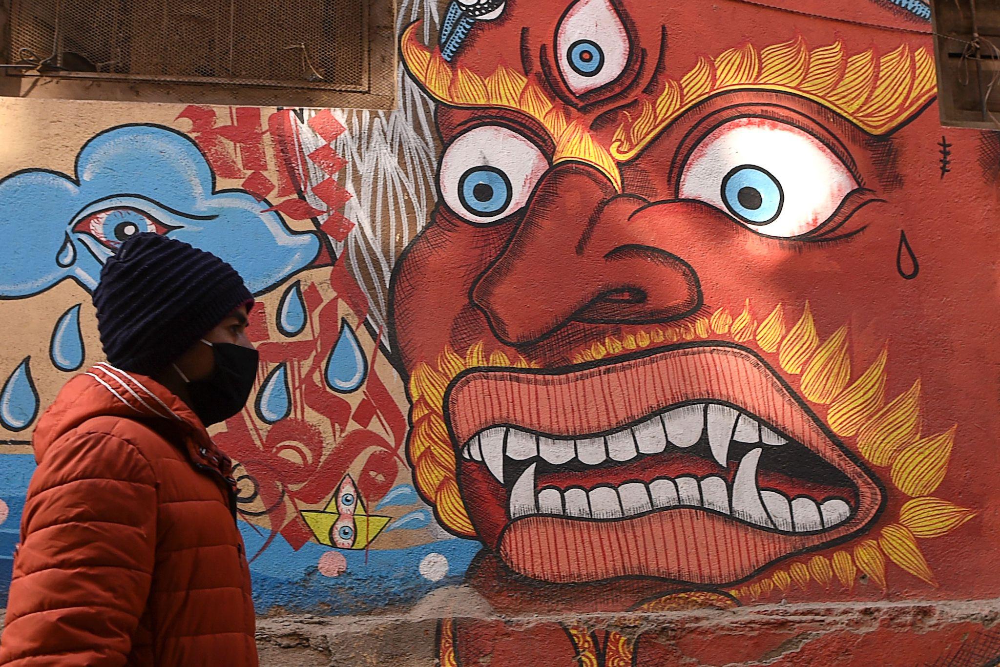 A resident wearing a protective facemask walks at the Patan Durbar Square area in Kathmandu on February 10, 2020