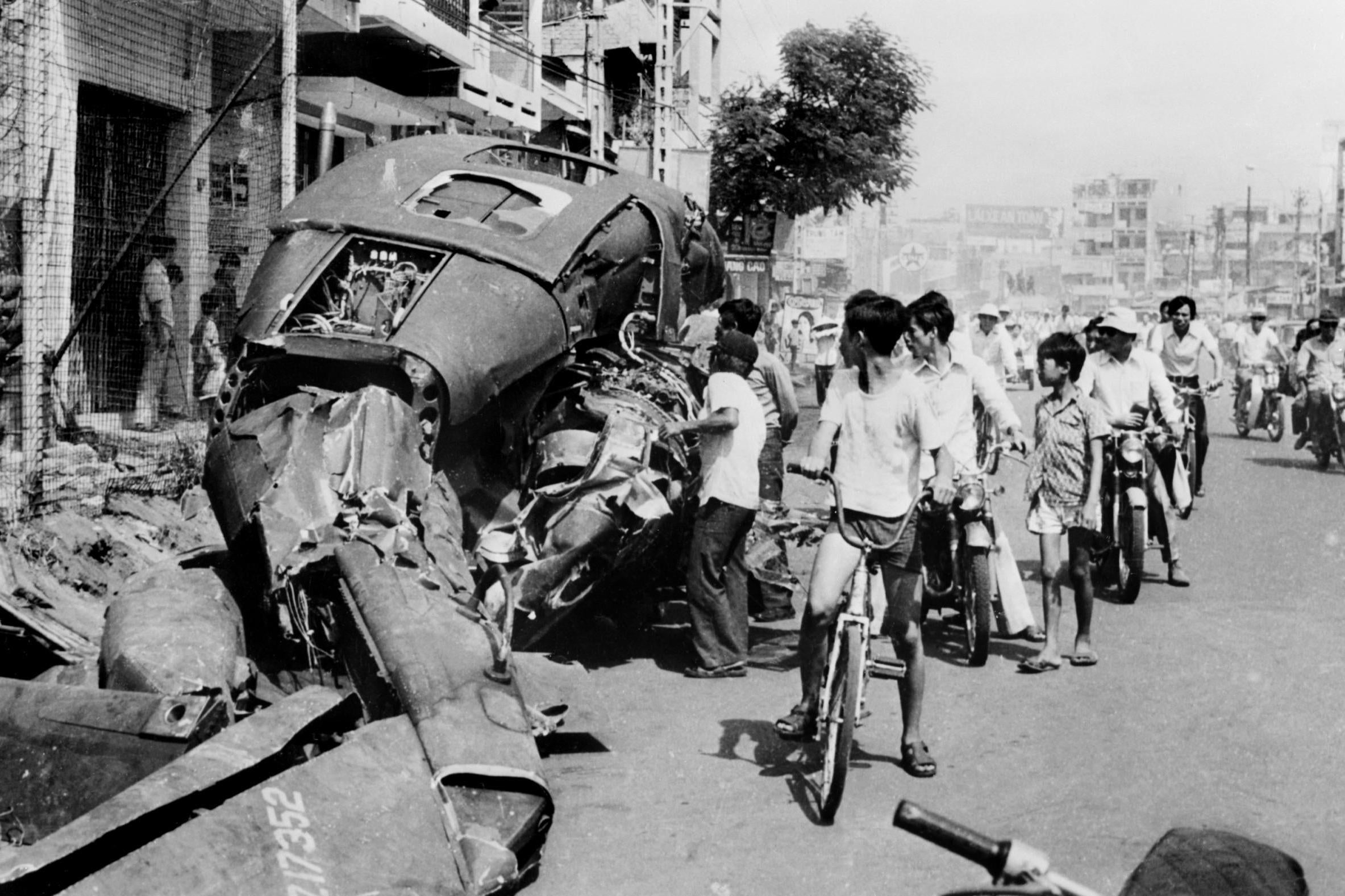 Residents looking at a US helicopter that was destroyed 29 April, the day before the takeover of Saigon