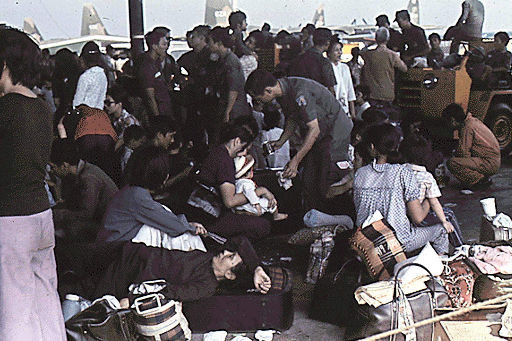 Vietnamese militants and civilians await the next step of their evacuation during a stopover Thailand