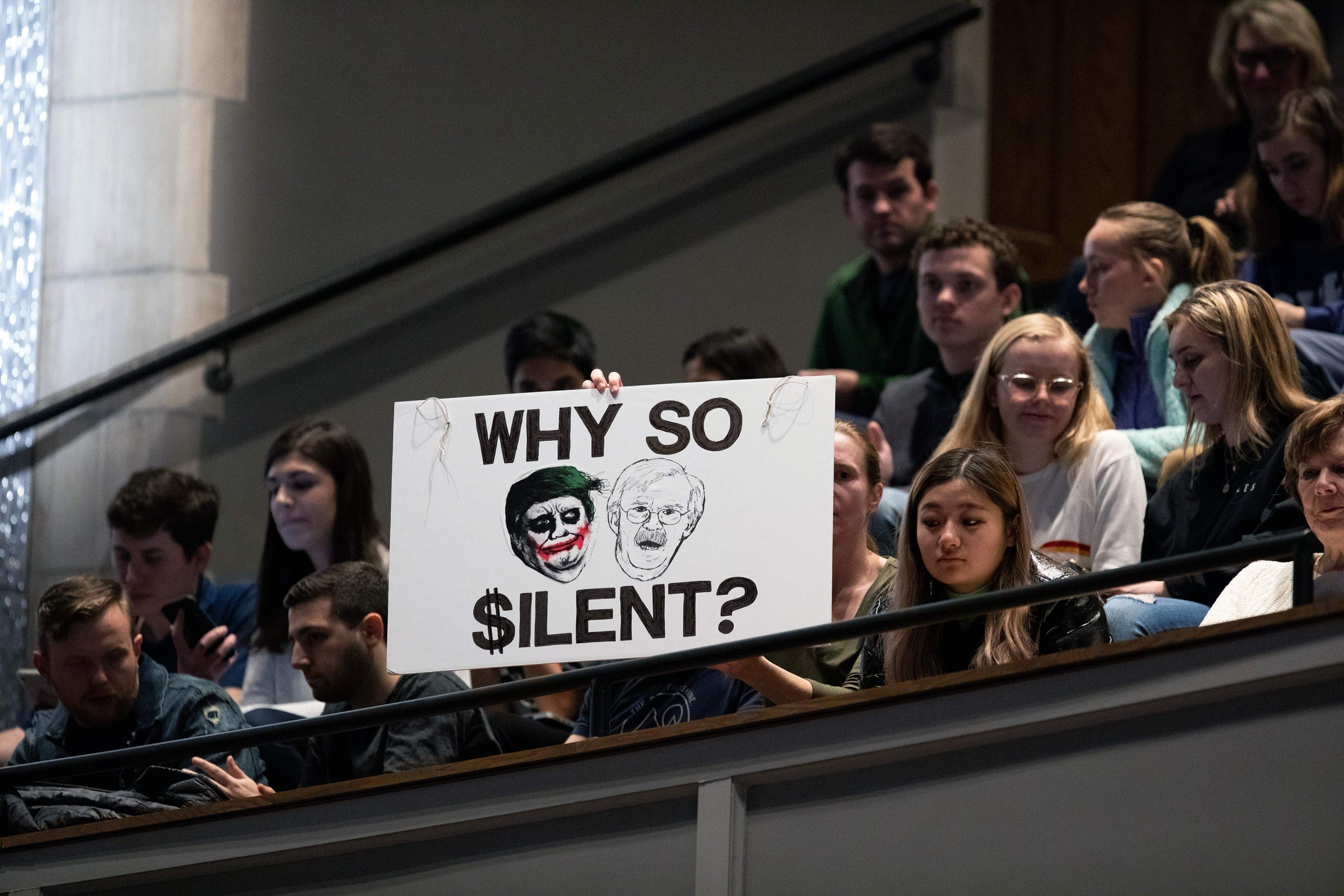 Protesters hold up a sign comparing Donald Trump to The Joker during a talk by former national security adviser at Duke University in North Carolina