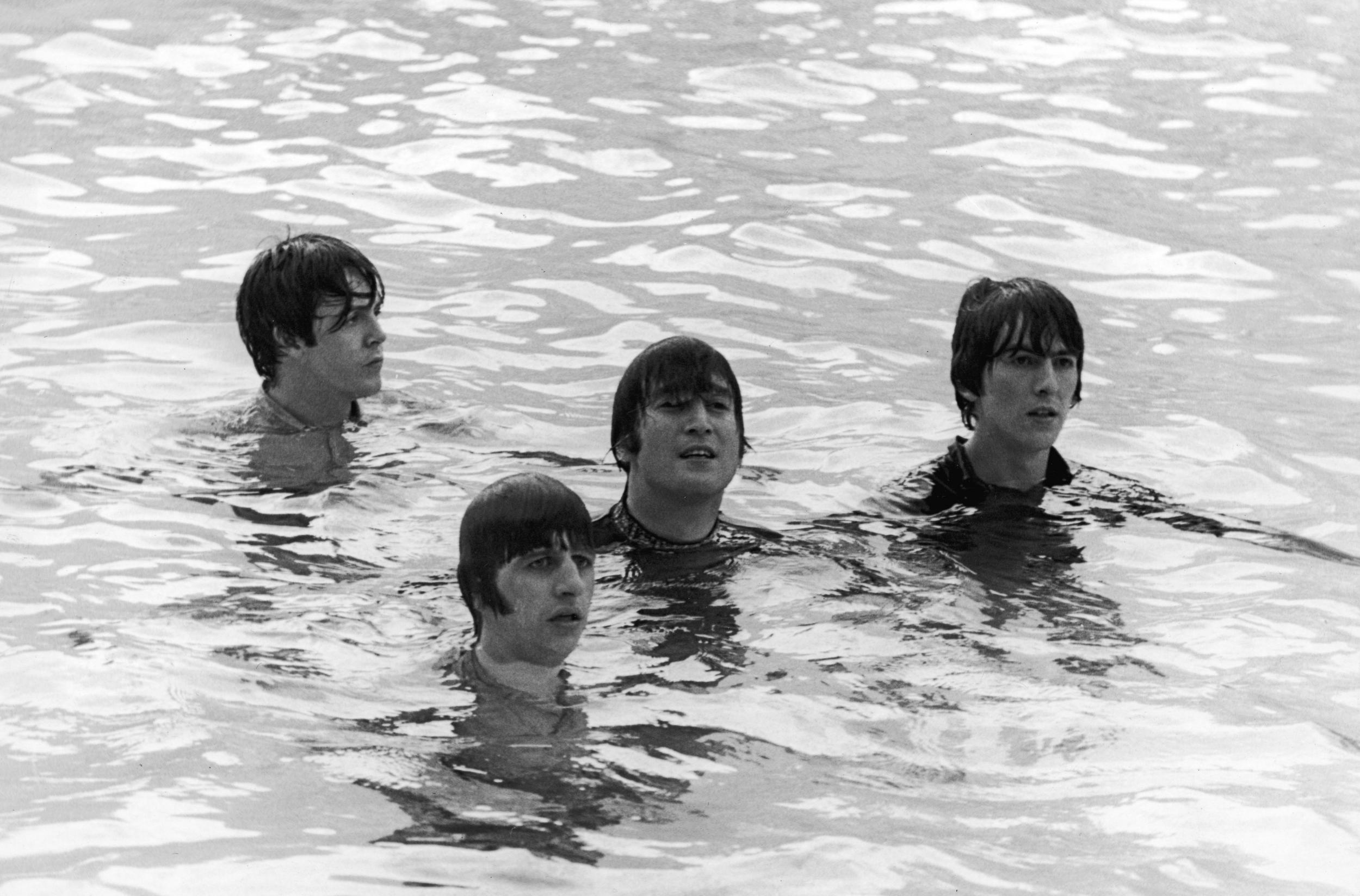 The Beatles tread water in a swimming pool during the filming of the movie