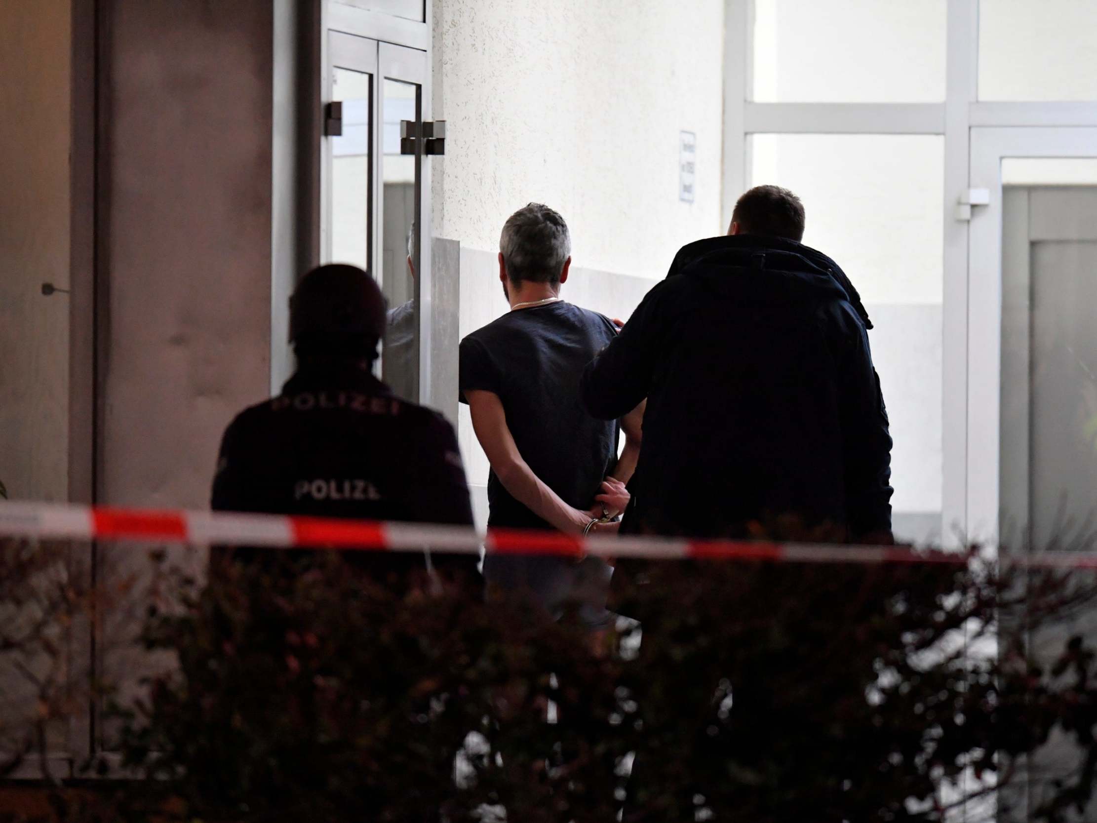 Police handcuff a man near the scene of a shooting in Hanau